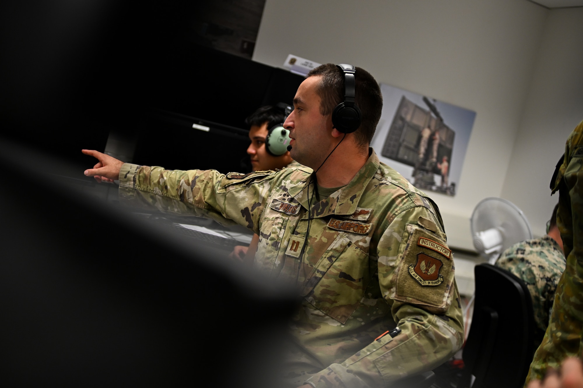 U.S. Air Force Capt. Chase Winans, 606th Air Control Squadron section lead, relays information to exercise participants during SPARTAN SHIELD 25-2 at Einsiedlerhof Air Station, Germany, September 25, 2025. The U.S. Army, U.S. Marine Corps, and U.S. Air Force came together during SPARTAN SHIELD 25-2 to exercise offensive air systems, while cementing tactics, techniques, and procedures of emerging threats. (U.S. Air Force photo by Capt. Benjamin Aronson)