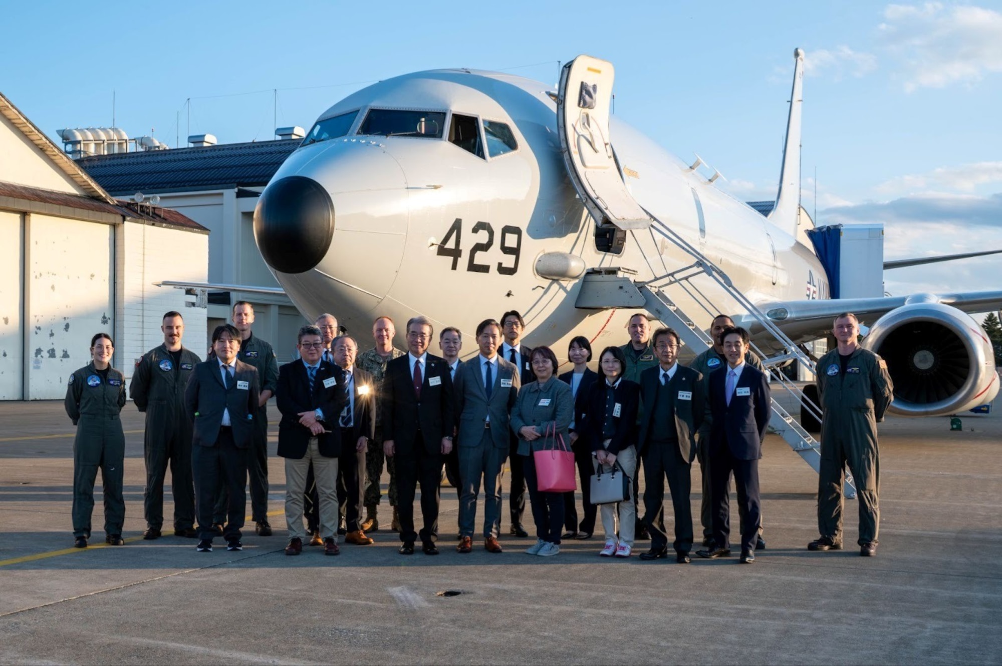 U.S. Sailors and Tohoku Defense Bureau members pose for a group photo in front of a U.S. Navy P-8 Poseidon during a visit at Misawa Air Base, Japan, Nov. 5, 2025.