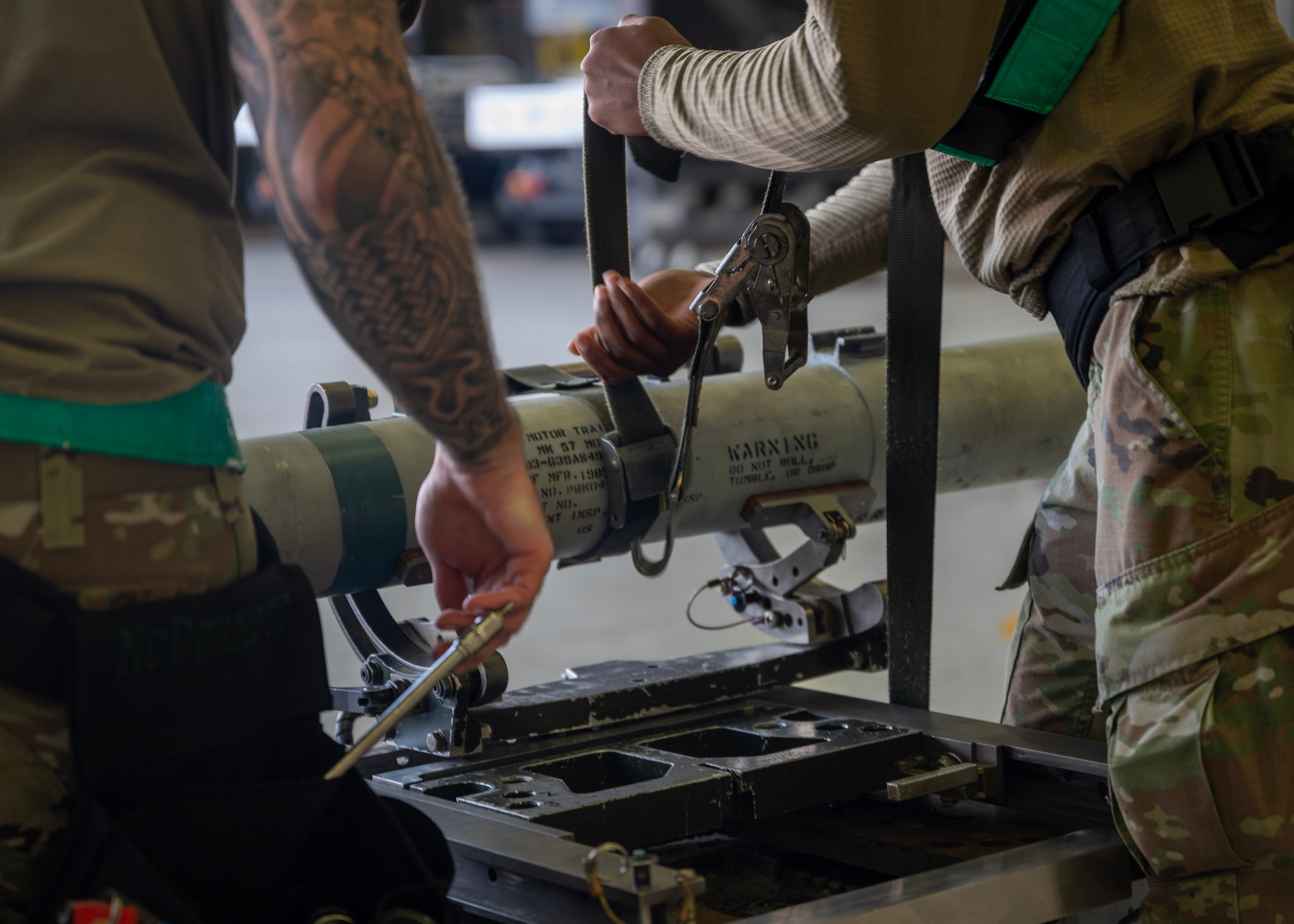 An Airman assigned to the 51st Maintenance Group/Operating Location tightens a strap during a weapons loading competition at Osan Air Base, Republic of Korea, Oct. 2, 2025. The competition tested the technical accuracy, adherence to safety protocols, team coordination and overall loading time of the weapons load crews as they loaded munitions onto F-16 Fighting Falcons. (U.S. Air Force photo by Staff Sgt. Sarah Williams)