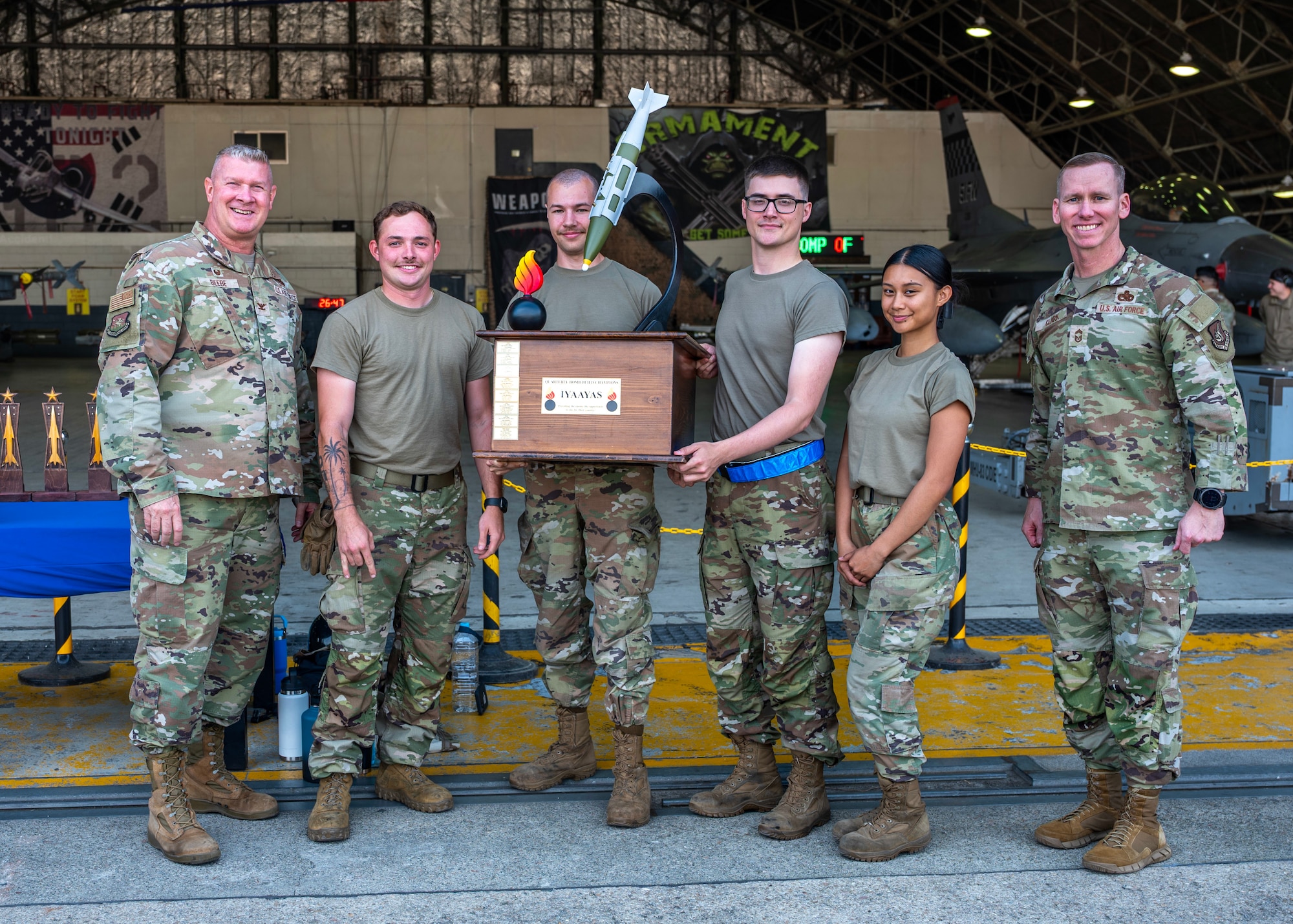 Airmen assigned to the 51st Munitions Squadron pose with 51st Maintenance Group leadership after winning the bomb building competition at Osan Air Base, Republic of Korea, Oct. 2, 2025. The Airmen were evaluated on technical accuracy, safety, speed and teamwork while rapidly assembling munitions. (U.S. Air Force photo by Staff Sgt. Sarah Williams)