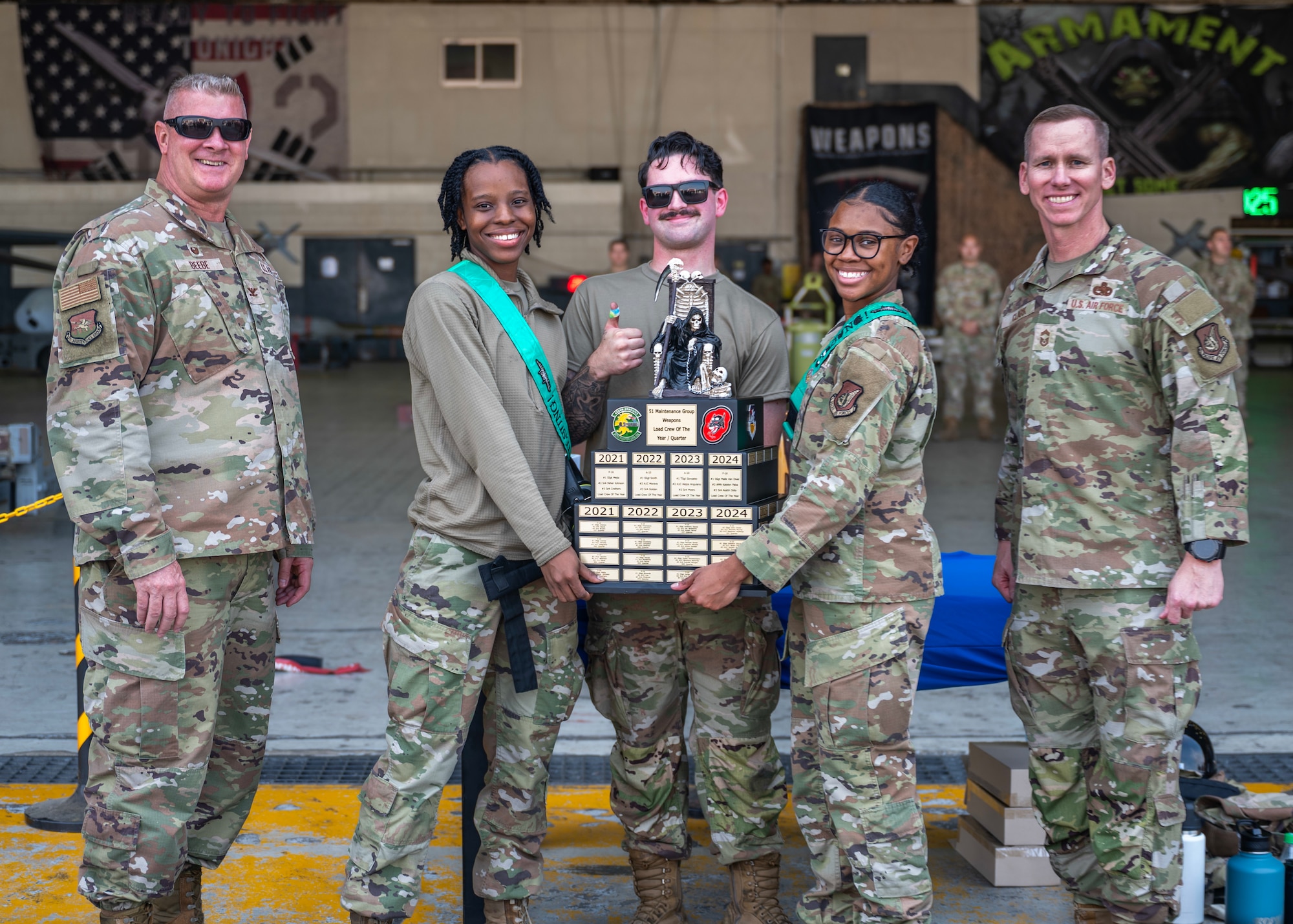 Airmen assigned to the 51st Maintenance Group/Operating Location pose with 51st Maintenance Group leadership after winning the weapons loading competition at Osan Air Base, Republic of Korea, Oct. 2, 2025. The competition tested the technical accuracy, adherence to safety protocols, team coordination, and loading time of the weapons load crews as they loaded munitions onto F-16 Fighting Falcons. (U.S. Air Force photo by Staff Sgt. Sarah Williams)