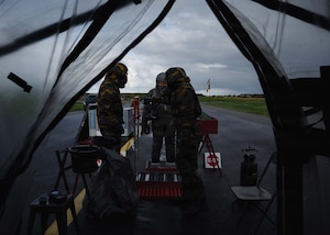U.S. Air Force Tech. Sgt. Arlin Anderson, center, 52nd Operations Support Squadron aircrew flight equipment lead trainer, processes through a decontamination line led by Belgian air force members during exercise Toxic Trip 25, at Ørland Air Base, Norway, Sept. 23, 2025.