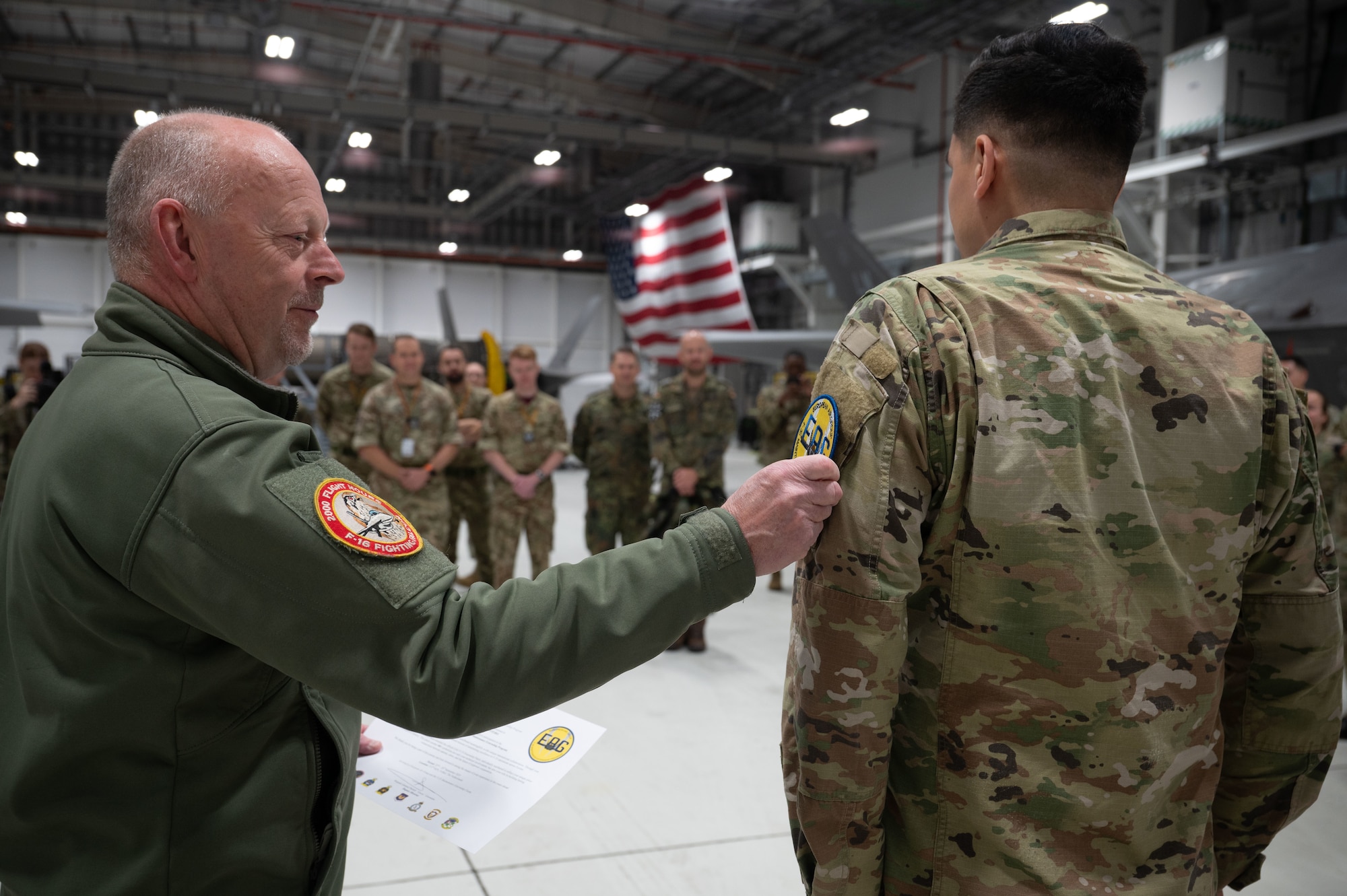 Brig Gen putting a patch on an airmen