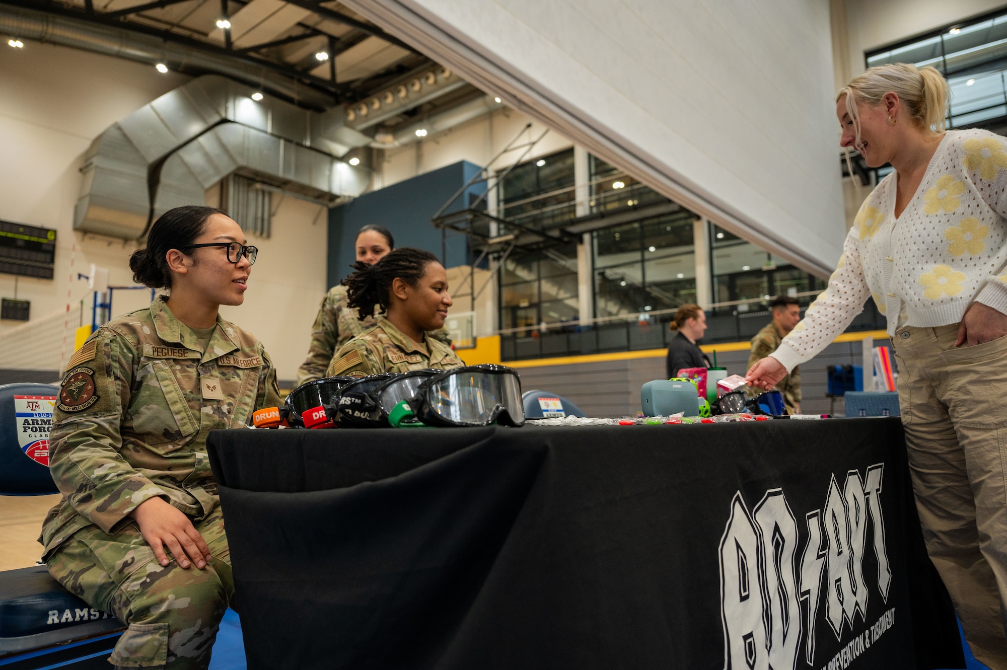 Airmen at the Alcohol and Drug Abuse Prevention and Treatment station discuss ADAPT resources to people during the October PT Month Health Fair at Ramstein Air Base, Germany, Oct. 17, 2025.