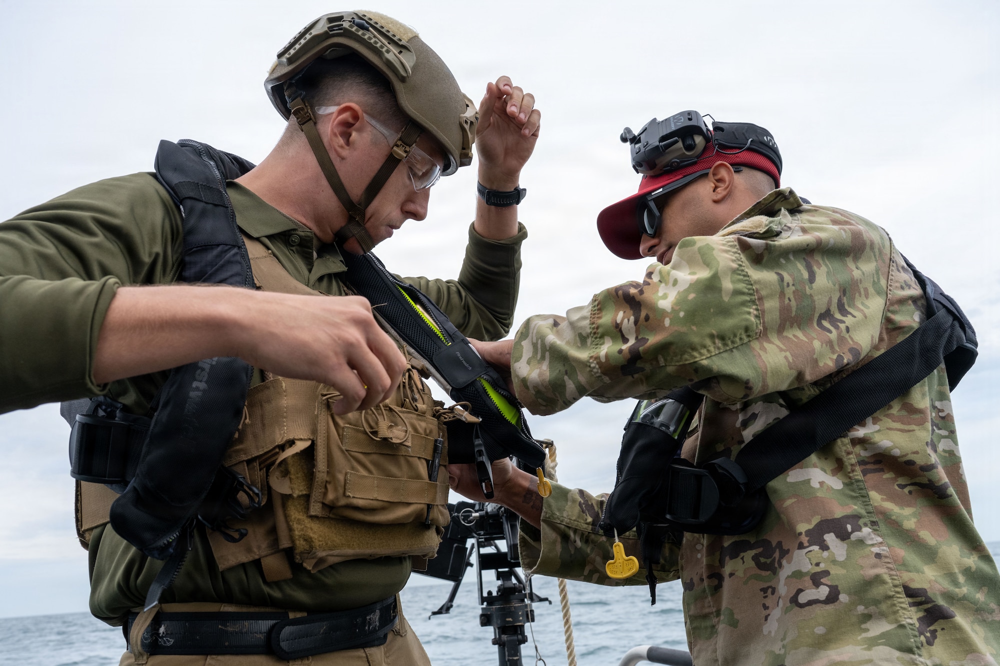 U.S. Air Force Tech. Sgt. Hunter Sterling, 6th Security Forces Squadron combat arms training and maintenance (CATM) section chief, assists Senior Airman Travis Westrick, a 6th SFS marine patrolman, with his life vest at MacDill Air Force Base, Florida, Nov. 6, 2025. Marine patrolmen are required to be certified in each weapon annually. CATM instructors ensure safety while helping improve a shooter's accuracy and confidence in the weapon. (U.S. Air Force photo by Airman Alexis Adams)