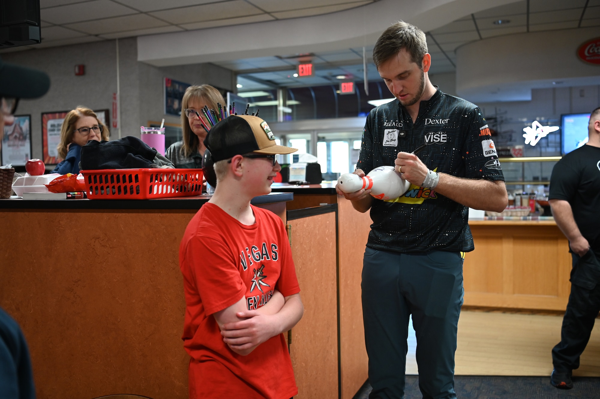 man signs bowling pin