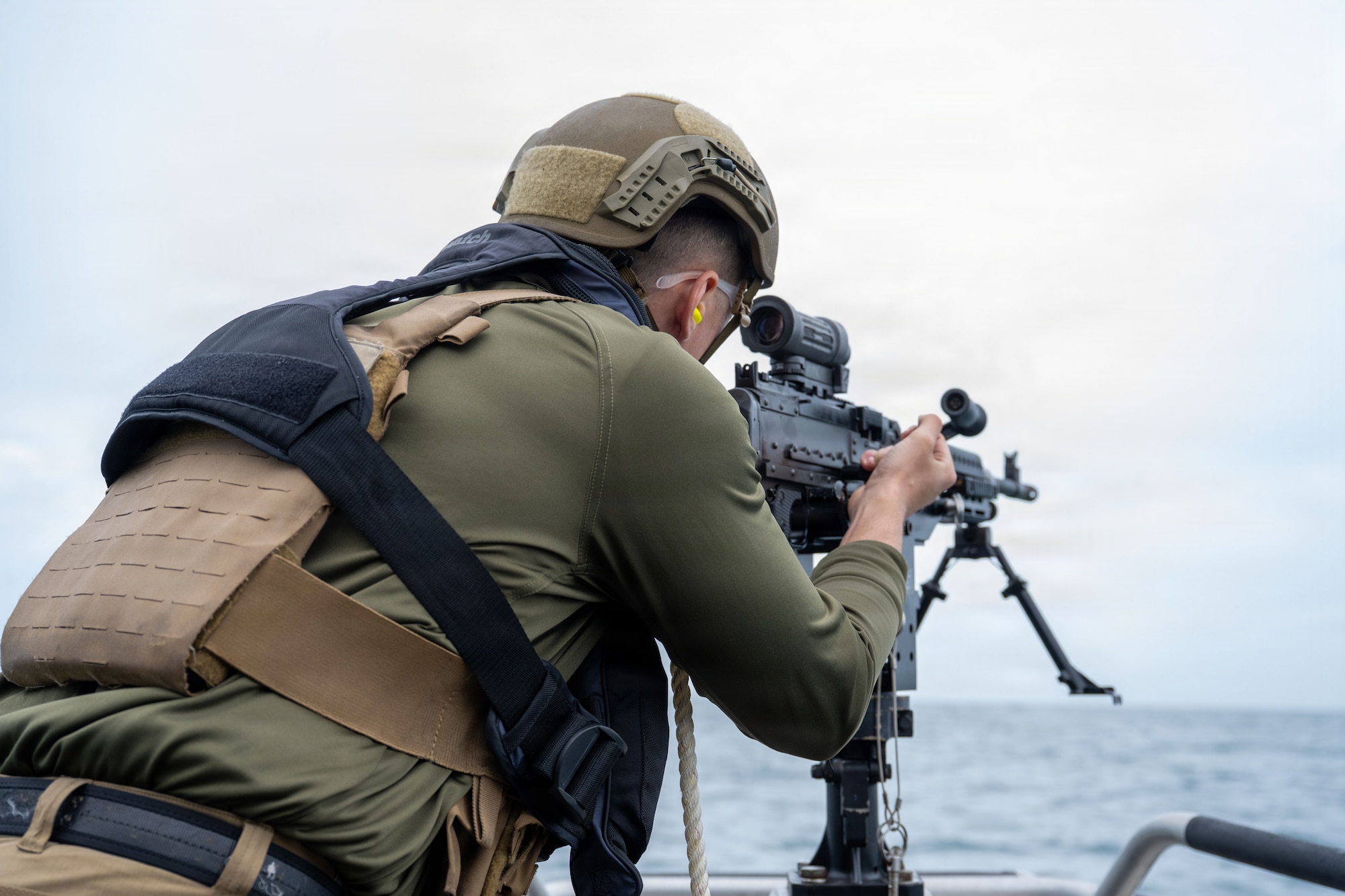 U.S. Air Force Senior Airman Travis Westrick, 6th Security Forces Squadron marine patrolman, fires a M240B machine gun off a vessel at MacDill Air Force Base, Florida, Nov. 6, 2025. Marine patrolmen are required to be certified in each weapon annually to increase their accuracy and stay familiar with the weapon. (U.S. Air Force photo by Airman Alexis Adams)