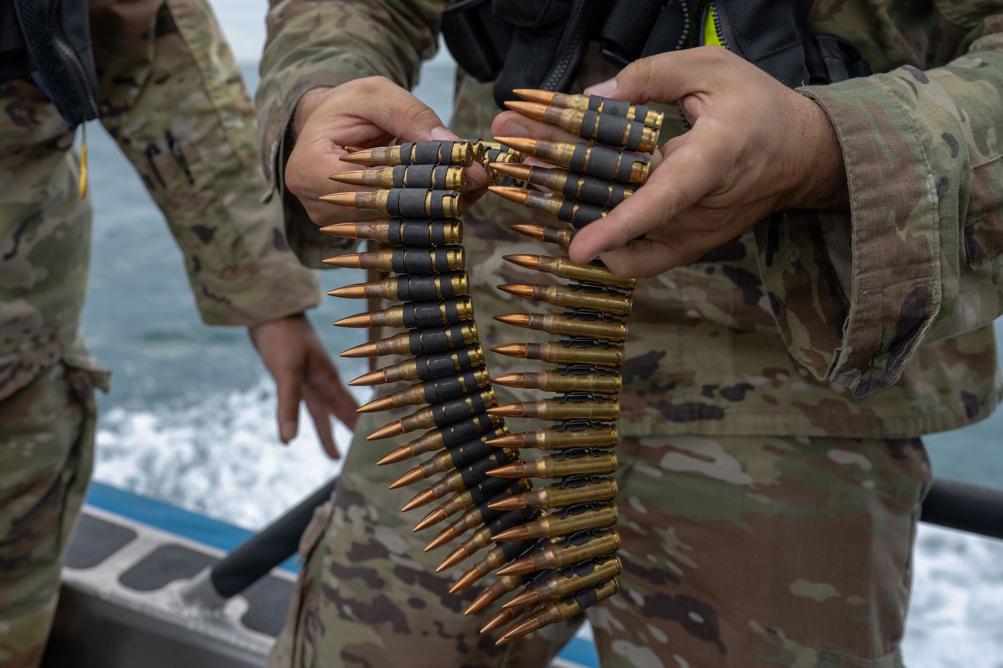 U.S. Air Force combat arms training and maintenance (CATM) instructors assigned to the 6th Security Forces Squadron prepare to load 7.62x51mm NATO ammunition into a M240B machine gun at MacDill Air Force Base, Florida, Nov. 6, 2025. CATM instructors ensure safety while helping improve a shooter's accuracy and confidence in the weapon. (U.S. Air Force photo by Airman Alexis Adams)