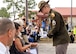 A soldier presents a ceremonial shell casing to the widow of Master Sgt. Gary Gordon who is sitting in the front row of the audience.