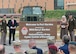 A large entrance sign reading Welcome to Fort Gordon named in honor of Master Sgt. Gary I Gordon. United States Army, Cyber Center of Excellence. with a soldier and civilian on the left and a woman and soldier on the right.