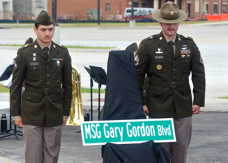 Two soldiers stand behind the newly unveiled street sign MSG Gary Gordon Boulevard