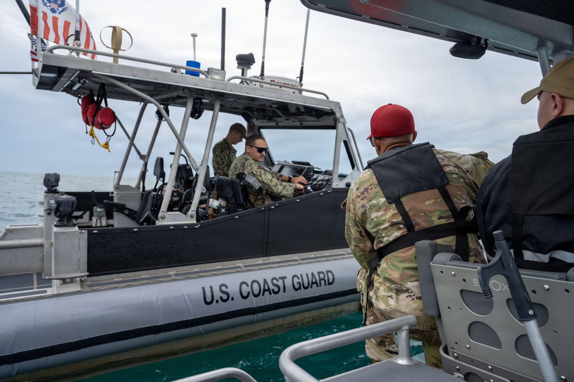 A U.S. Air Force marine patrol vessel 22-1 assigned to the 6th Security Forces Squadron interacts with a U.S. Coast Guard vessel during an annual weapons training at MacDill Air Force Base, Florida, Nov. 6, 2025. The USAF and USCG work together to ensure waters are clear and safe of other boaters before firing weapons. (U.S. Air Force photo by Airman Alexis Adams)