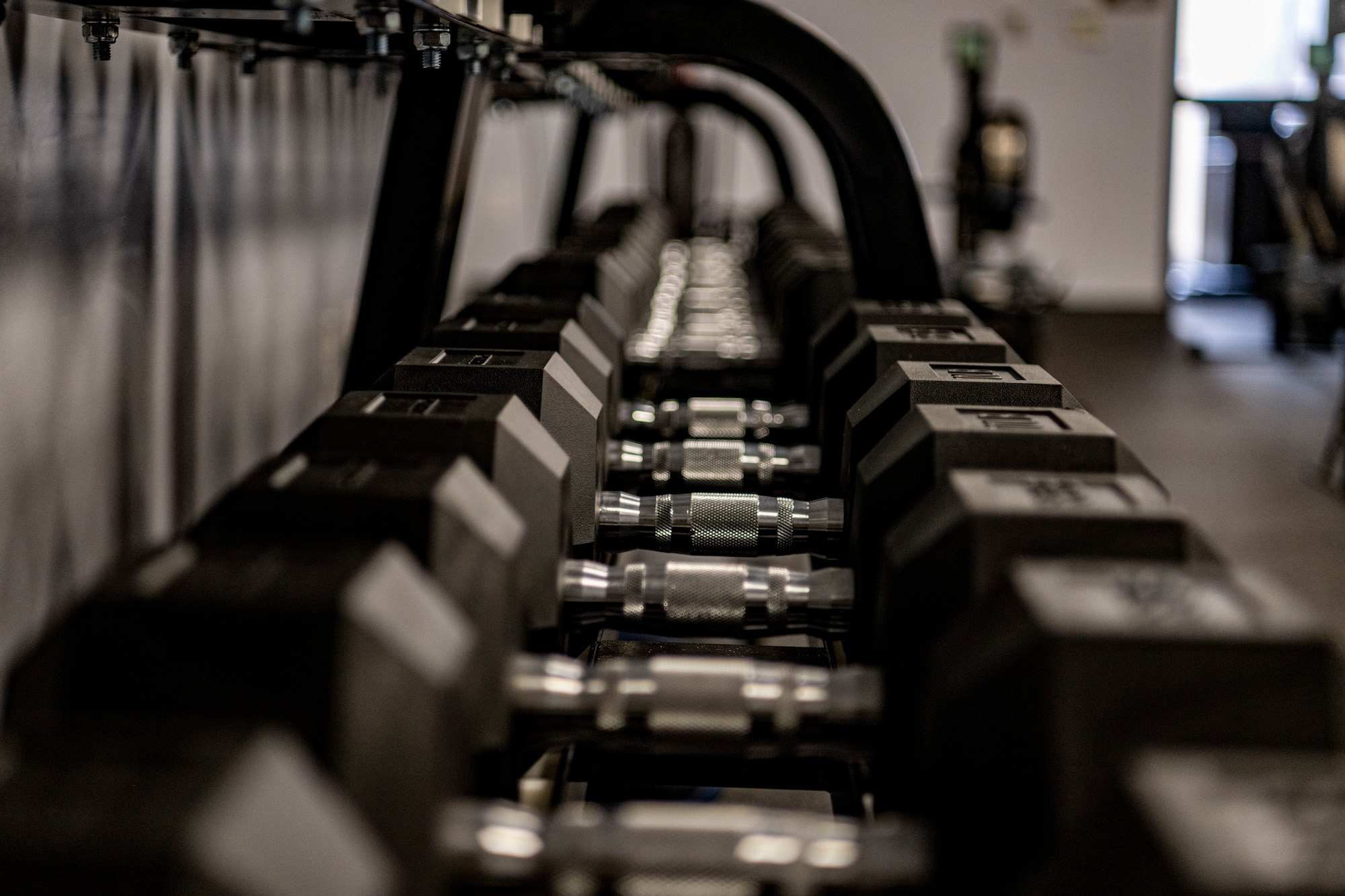 A photo of the interior of a gym with racks of free weights and other exercise equipment