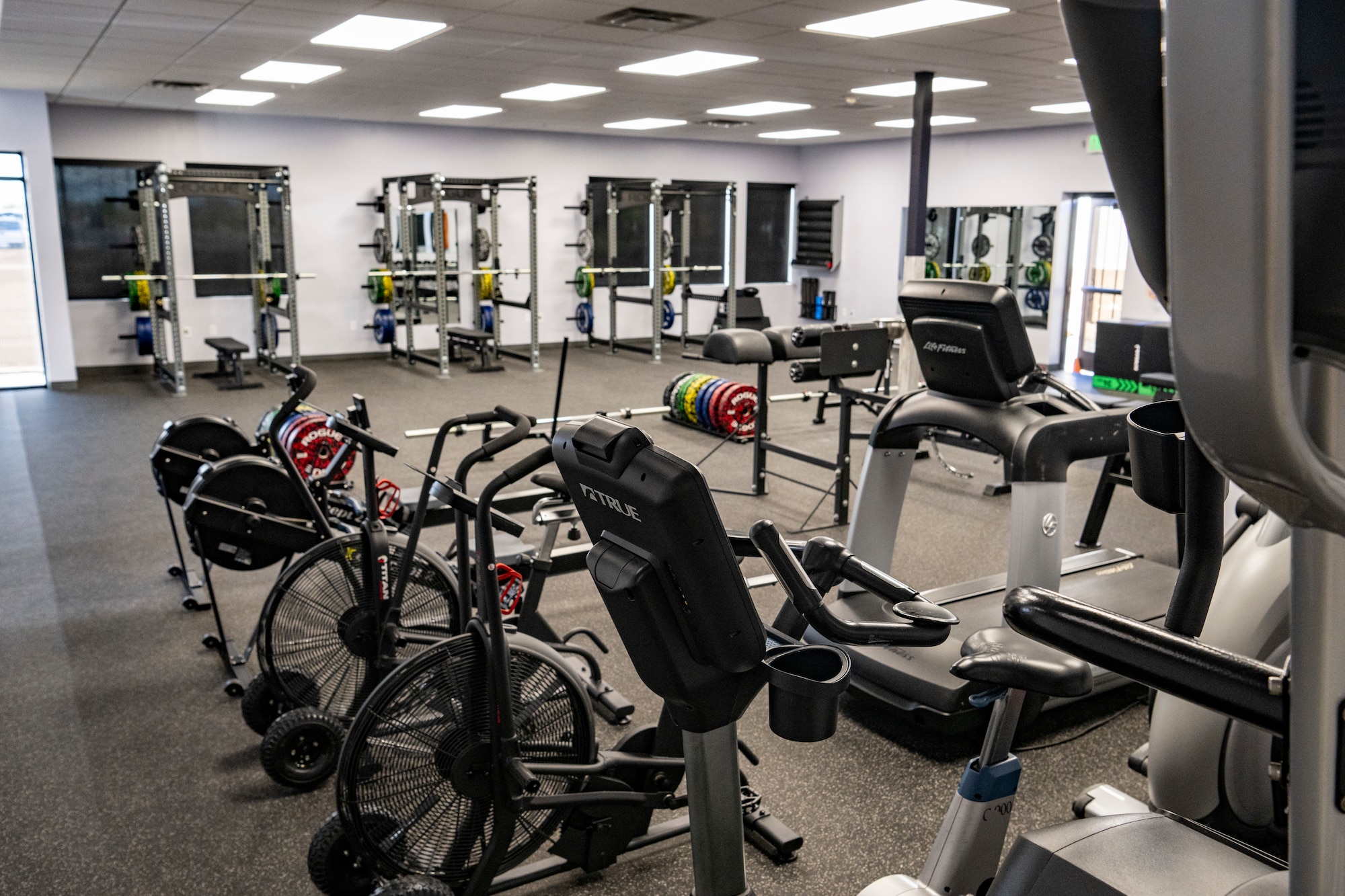 A photo of the interior of a gym with racks of free weights.