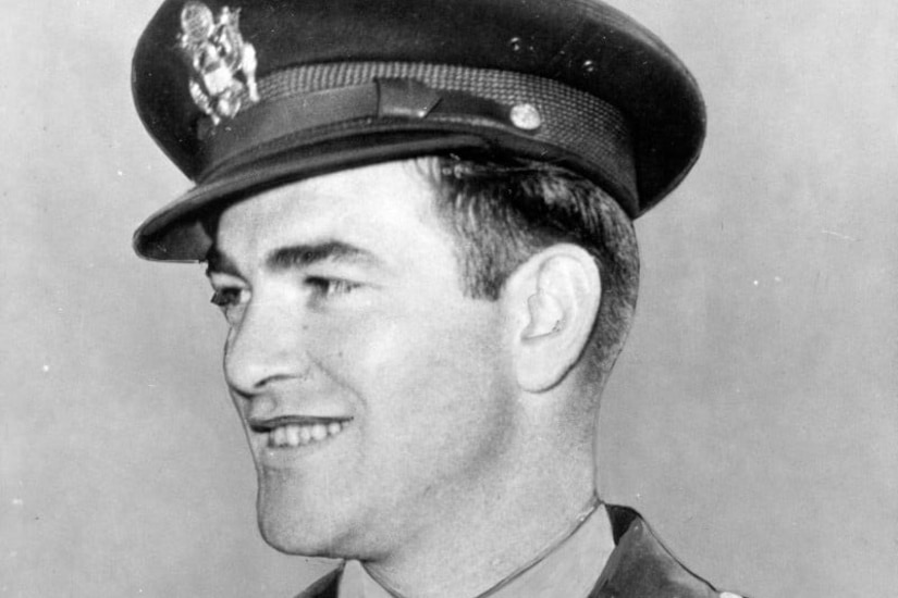 A man in a uniform and cap poses for a photo.