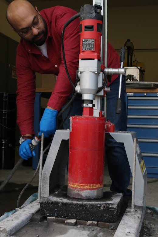 Dr. Mohamed Elshaer cores a cylindrical specimen from a lab-compacted slab for bulk density measurement and performance-based cracking evaluation.