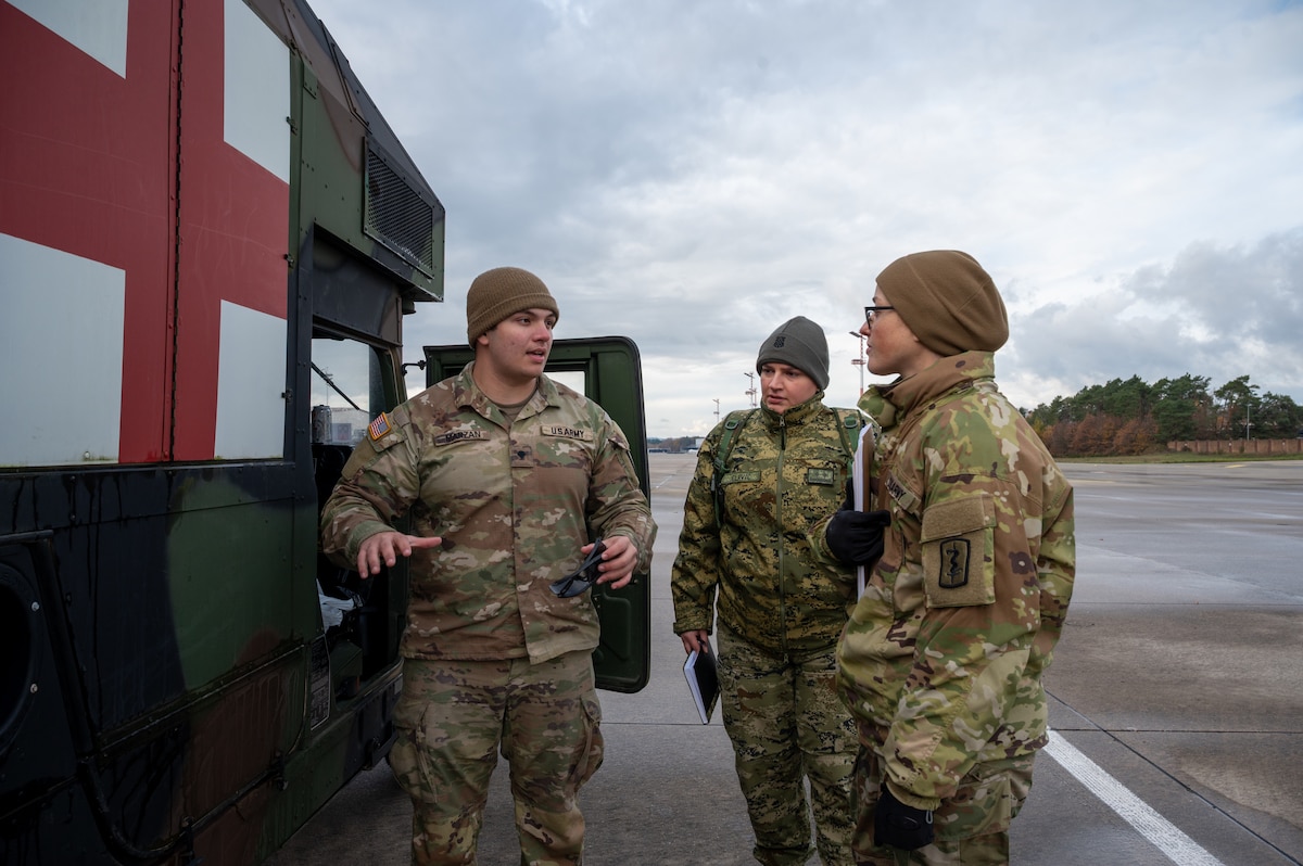 U.S. Army Spc. Lucas Marzan,16th Sustainment Brigade combat medic, explains the capabilities of a field litter ambulance to two NATO Medical Evaluation Course students during a mock evaluation at Ramstein Air Base, Germany, Nov. 20, 2025.