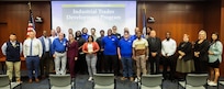 During a NSWCPD ceremony held September 9th, the first cohort of ten graduates from the Industrial Trades Development Program (ITDP) crossed a symbolic line, receiving their certificates and command coins, marking the end of 18 months of intensive hands-on training and classroom instruction. (Photo by Specialist 4 Nate Tate)