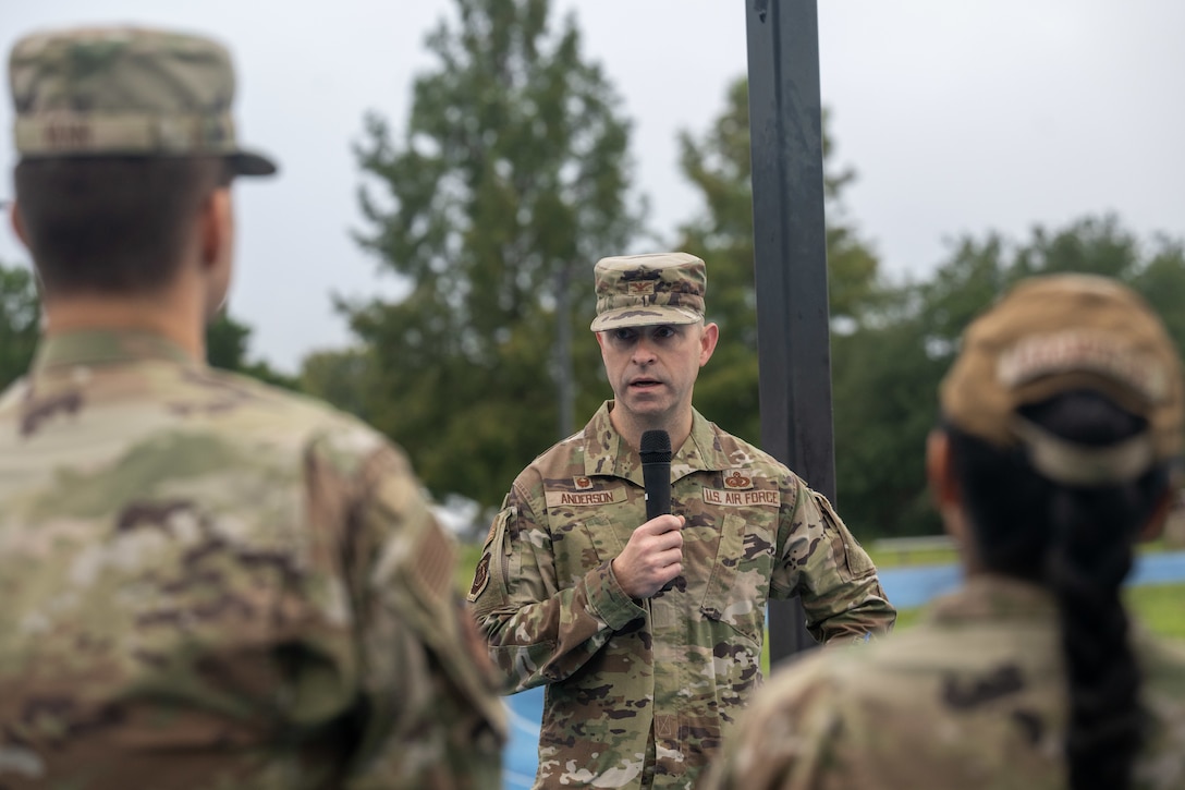 A man in uniform talks into a microphone.