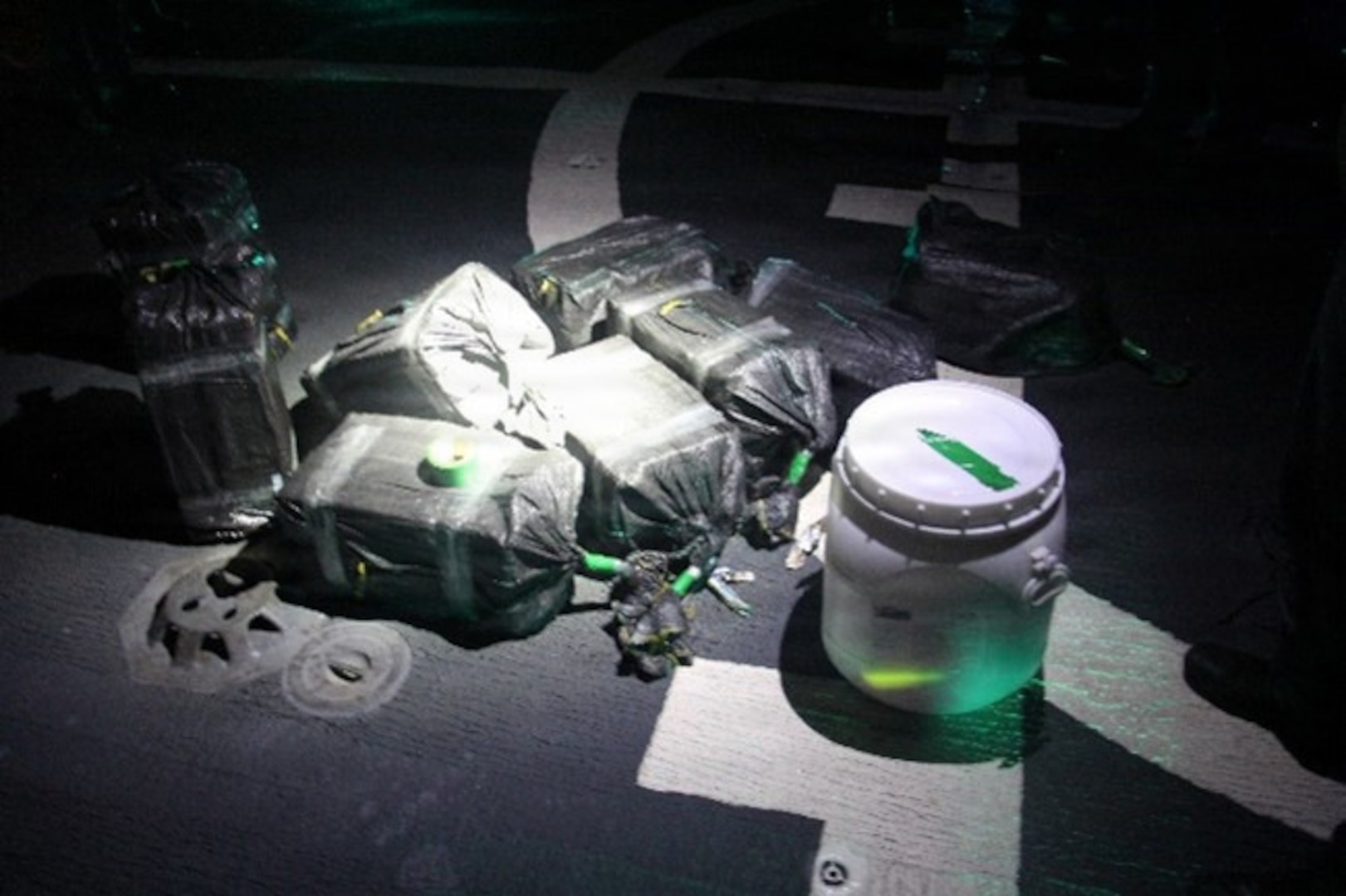 Coast Guard Cutter Tampa's (WMEC 902) crew displays contraband seized during a recent interdiction on the flight deck about 270 nautical miles southeast of the Galapagos Islands in the Pacific Ocean, Oct. 8, 2025. The interdiction was part of counterdrug operations in the Eastern Pacific. (U.S. Coast Guard photo by Petty Officer 2nd Class Gunner Revlett)