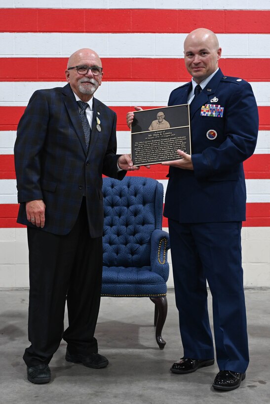 U.S. Air Force Lt. Col. Daniel Moritz, 28th Logistics Readiness Squadron commander, presents Dale Landis, 28th LRS vehicle management flight chief and fleet manager, with a plaque of dedication at Ellsworth Air Force Base, S.D., July 24, 2025.