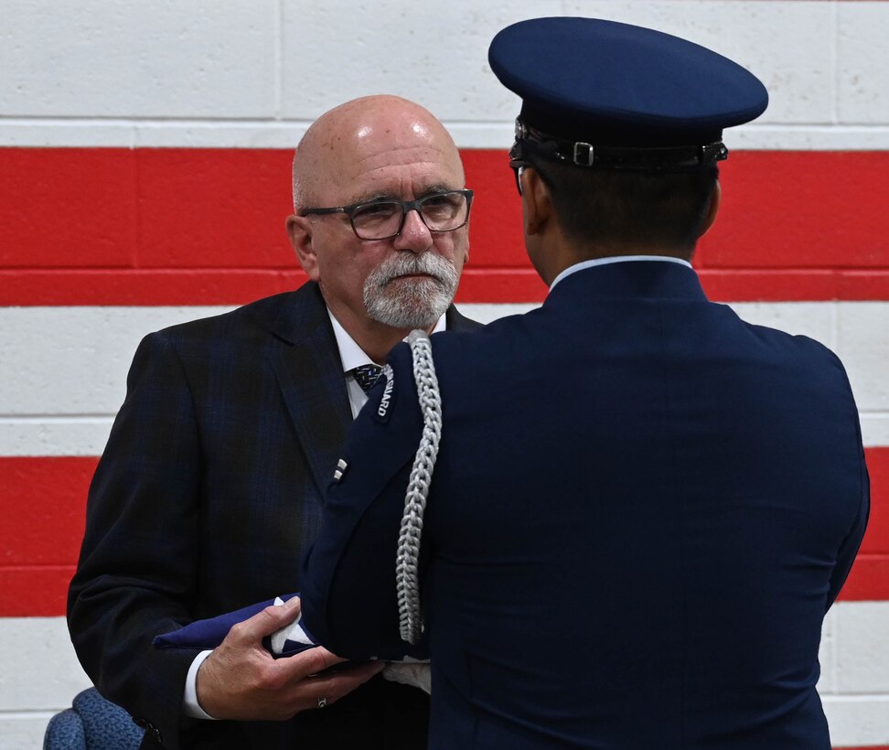 Dale Landis, 28th Logistics Readiness Squadron vehicle management flight chief and fleet manager, receives a folded American flag from a base honor guardsmen at Ellsworth Air Force Base, S.D., July 24, 2025.