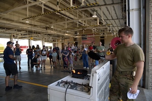 A man places a lid on a pan while putting out a pan fire.