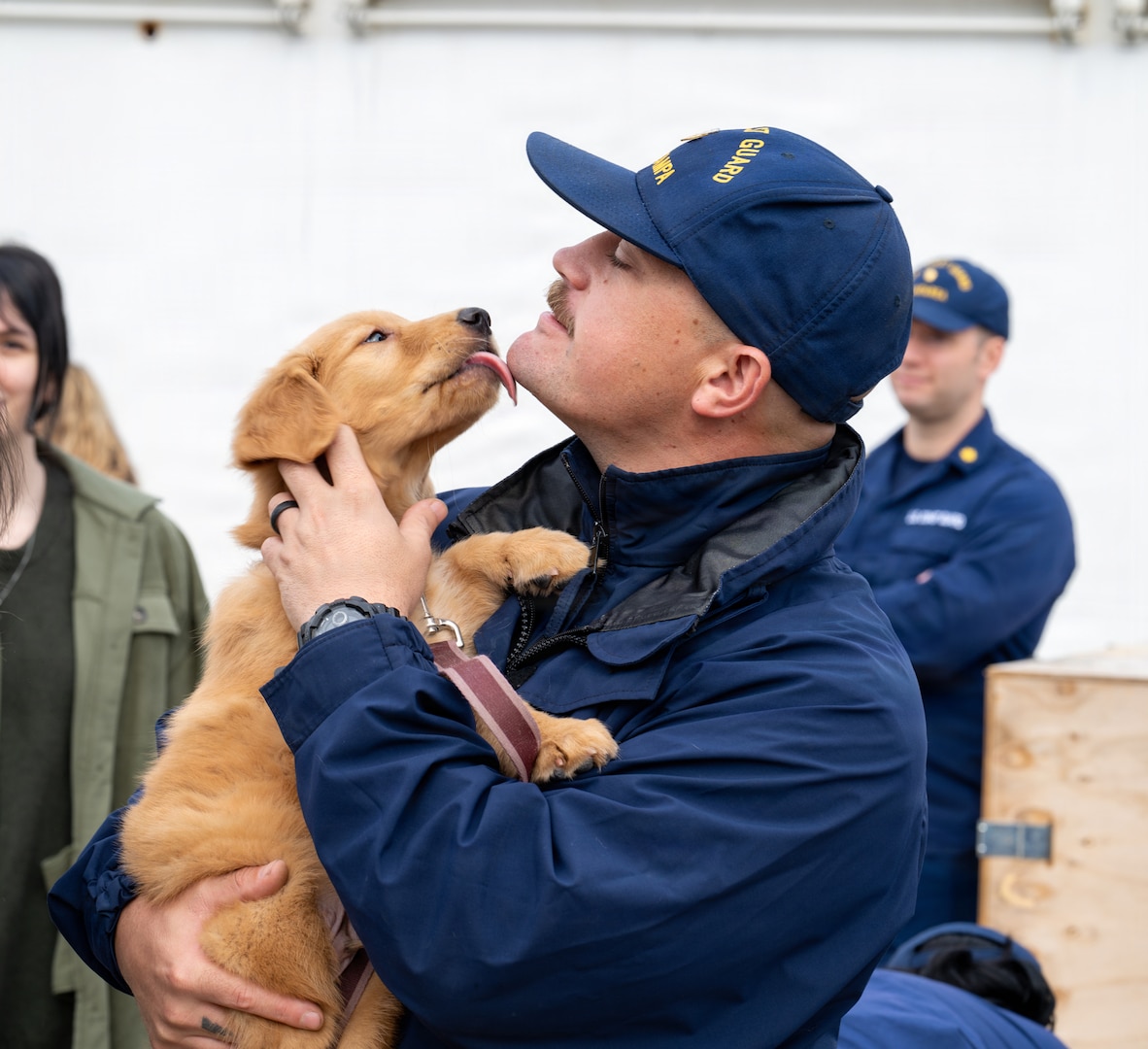 A Coast Guard crewmember reunites with his dog during Coast Guard Cutter Tampa’s (WMEC 902) homecoming in Portsmouth, Virginia, on Nov. 21, 2025. Tampa’s crew deployed in support of counterdrug operations in the Eastern Pacific. (U.S. Coast Guard photo by Petty Officer 3rd Class Mason Svitenko)