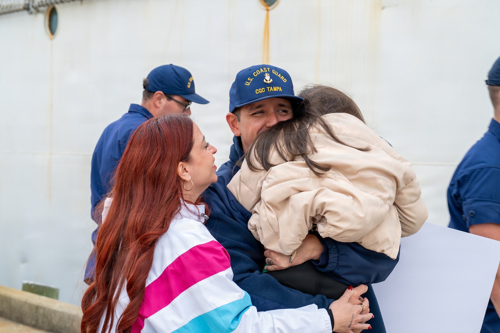 A Coast Guard crewmember’s family greets him as Coast Guard Cutter Tampa (WMEC 902) returns to homeport in Portsmouth, Virginia, on Nov. 21, 2025. Tampa’s crew deployed in support of counterdrug operations in the Eastern Pacific. (U.S. Coast Guard photo by Petty Officer 3rd Class Mason Svitenko)