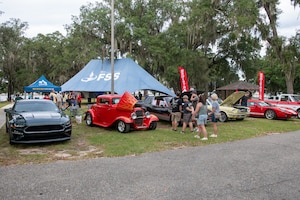 People walk around antique cars.