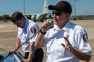 A man in uniform speaks into a CB radio