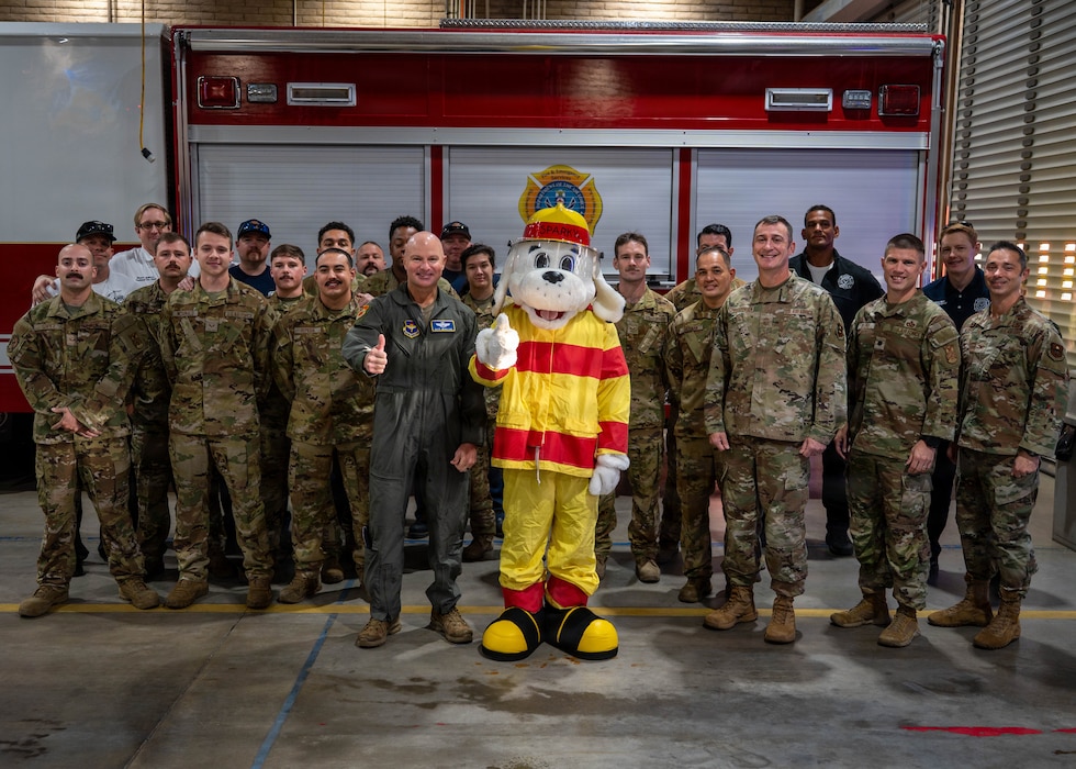 U.S. Air Force Brig. Gen. David Berkland, 56th Fighter Wing commander, and Airmen pose for a group photo with Sparky the Fire Dog after an awareness event, Oct. 6, 2025, at Luke Air Force Base, Arizona. The Fire Prevention team conducted awareness and education training for residents, which led to a significant decline in mishaps and reinforced Luke’s commitment to safety and readiness.