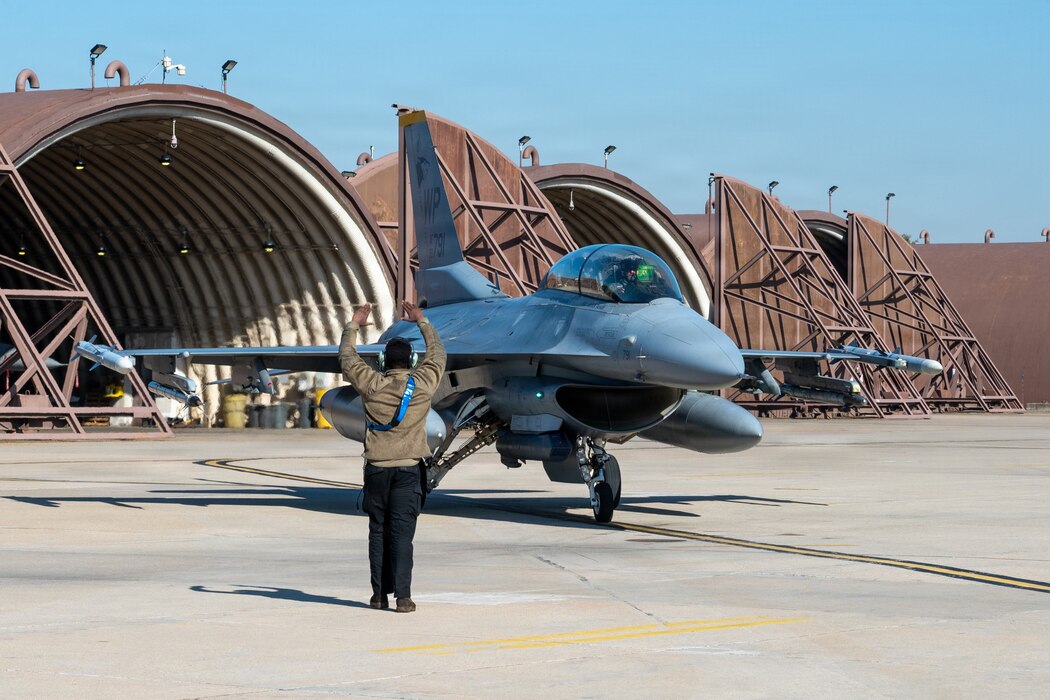 A maintainer assigned to the 51st Maintenance Group operating location marshals a U.S. Air Force F-16 Fighting Falcon assigned to the 35th Fighter Squadron after arriving at Osan Air Base, Republic of Korea, Nov. 21, 2025.