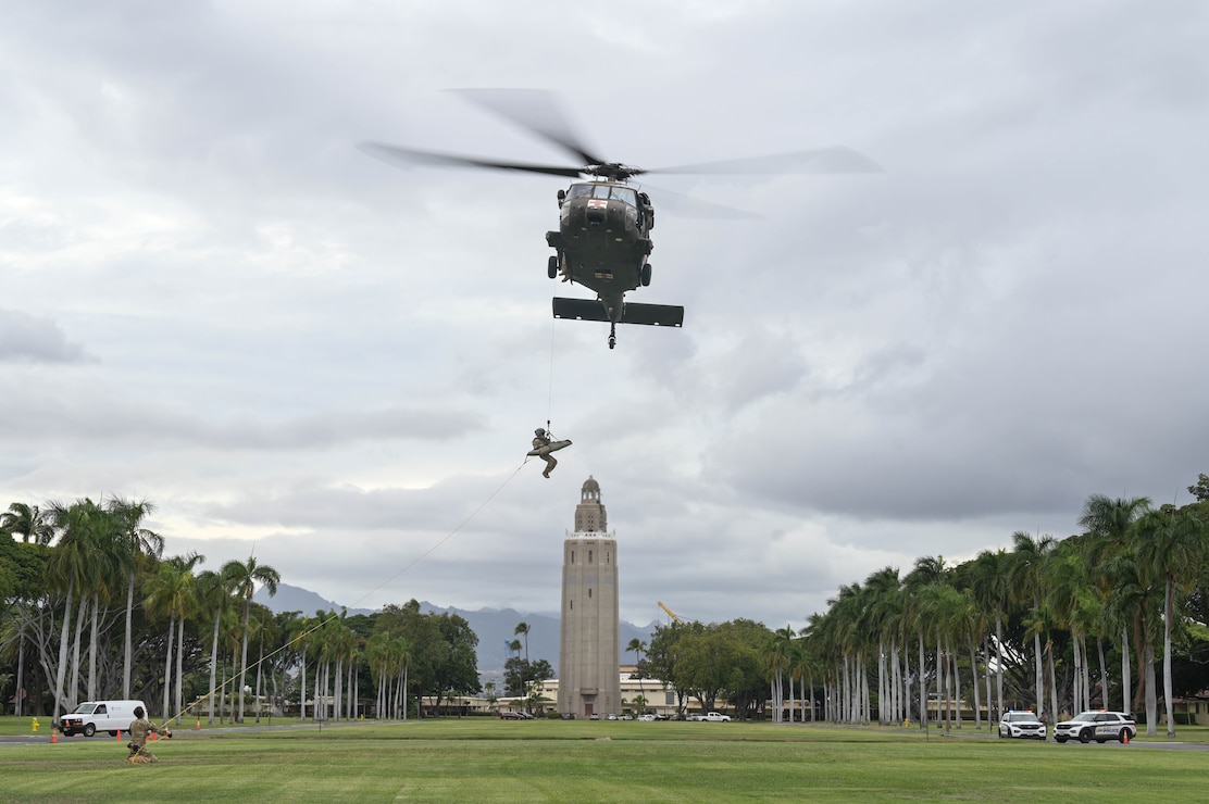 A helicopter lifting a soldier into the air.