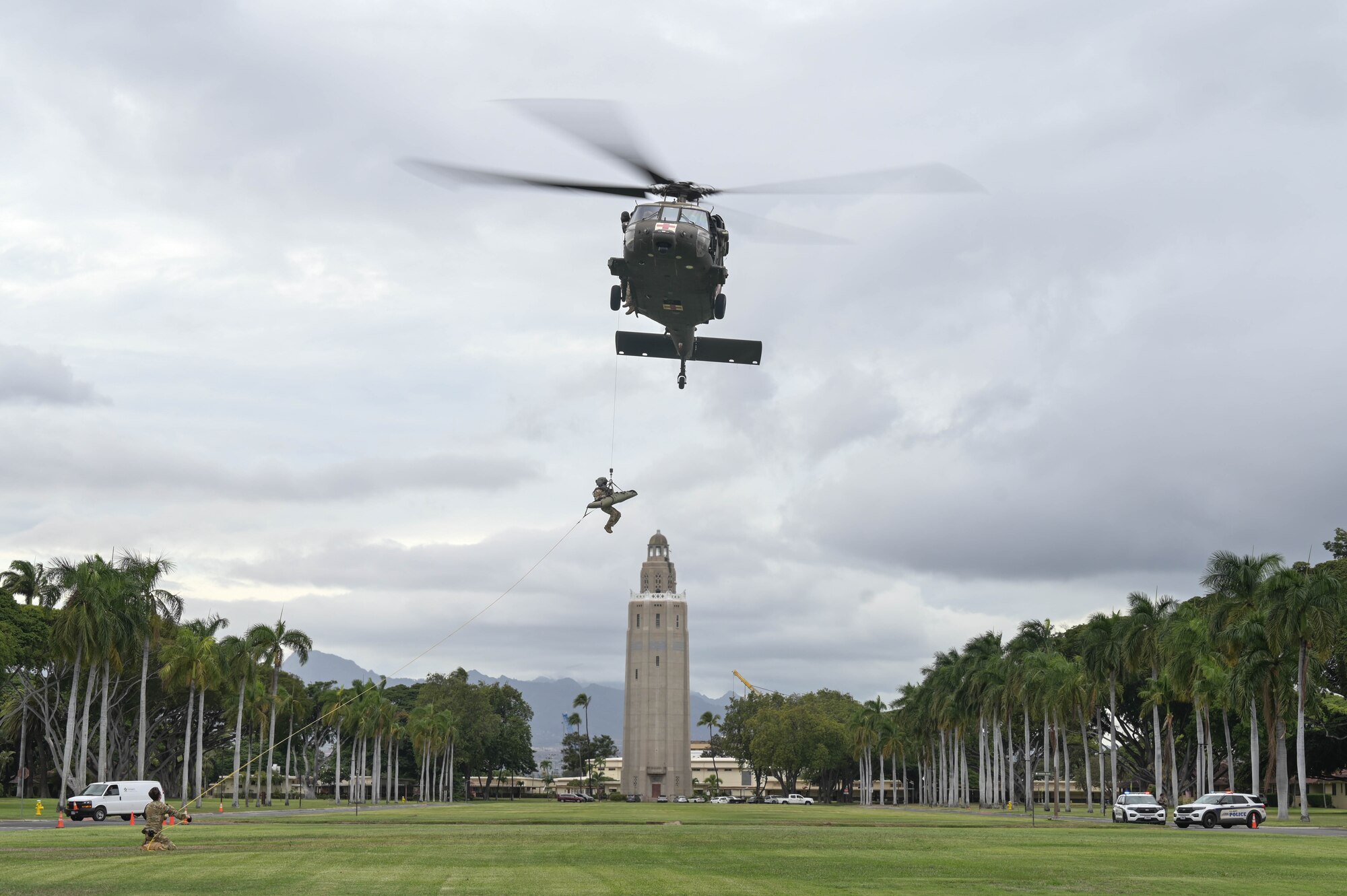 A helicopter lifting a soldier into the air.