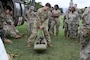 A soldier teaching Airmen on medical evacuation equipment use.