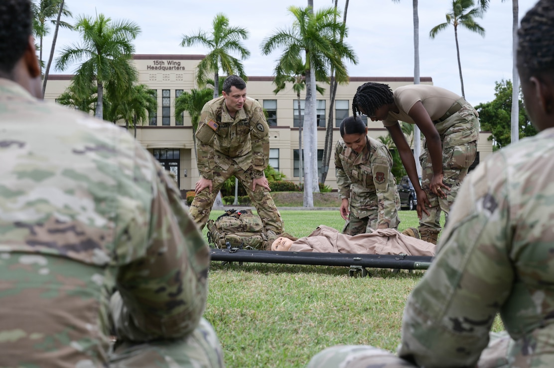 Soldier teaching Airmen on medical procedures.