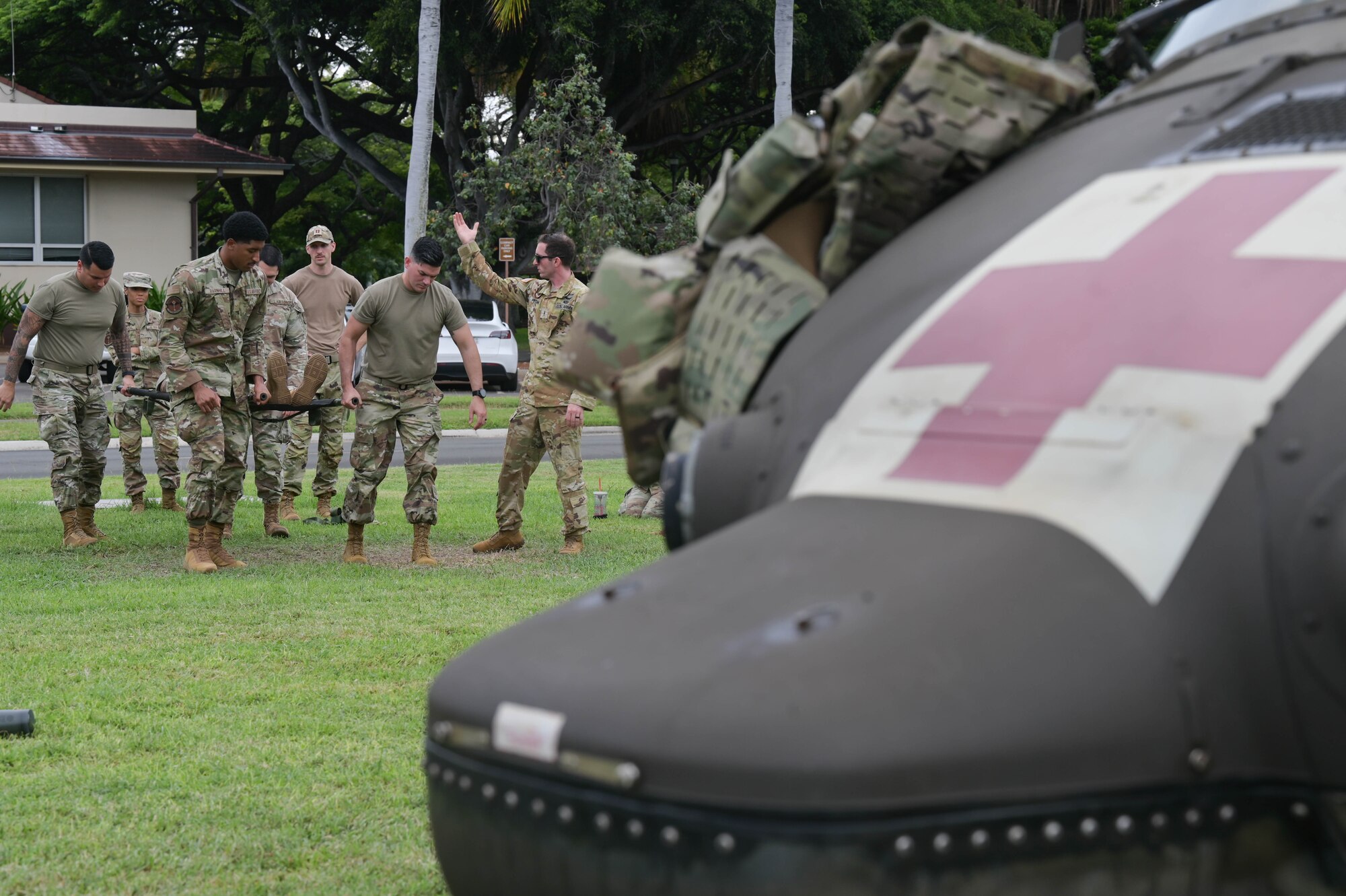 Airmen doing a litter carry to a helicopter.