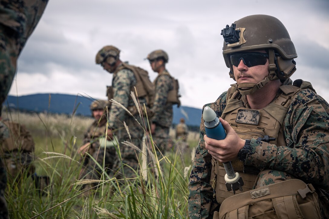 U.S. Marine Corps Lance Cpl. Joseph Meehan, a mortarman with Animal Company, Battalion Landing Team 1st Battalion, 7th Marine Regiment, 31st Marine Expeditionary Unit, prepares a 60mm mortar round during live-fire training at Combined Arms Training Center, Camp Fuji, Japan, Sept. 30, 2025. Marines conducted combined arms live-fire training to maintain operational readiness, tactical proficiency, and enhance lethality while operating within the first island chain. The 31st MEU, the Marine Corps’ only continuously forward-deployed MEU, provides a flexible and lethal force ready to perform a wide range of military operations as the premiere crisis response force in the Indo-Pacific region. (U.S. Marine Corps photo by Lance Cpl. Victor Gurrola)