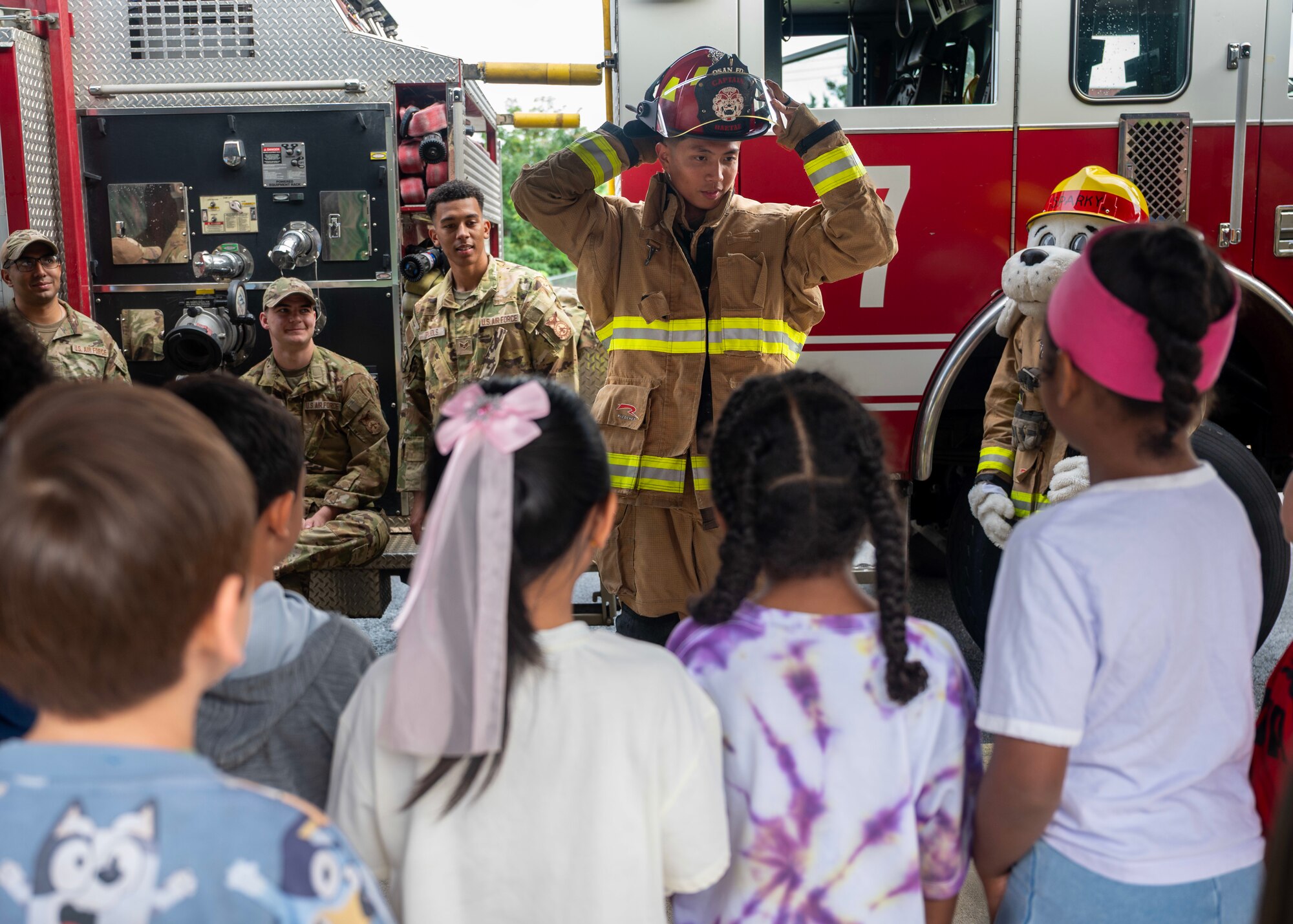 U.S. Air Force Senior Airman Jonathan Laguerta, 51st Civil Engineer Squadron firefighter, demonstrates how to suit up during Fire Prevention Week at Osan Air Base, Republic of Korea, Oct. 8, 2025. Fire Prevention Week focuses on providing the knowledge and tools to react quickly during a fire emergency. (U.S. Air Force photos by Staff Sgt. Sarah Williams)