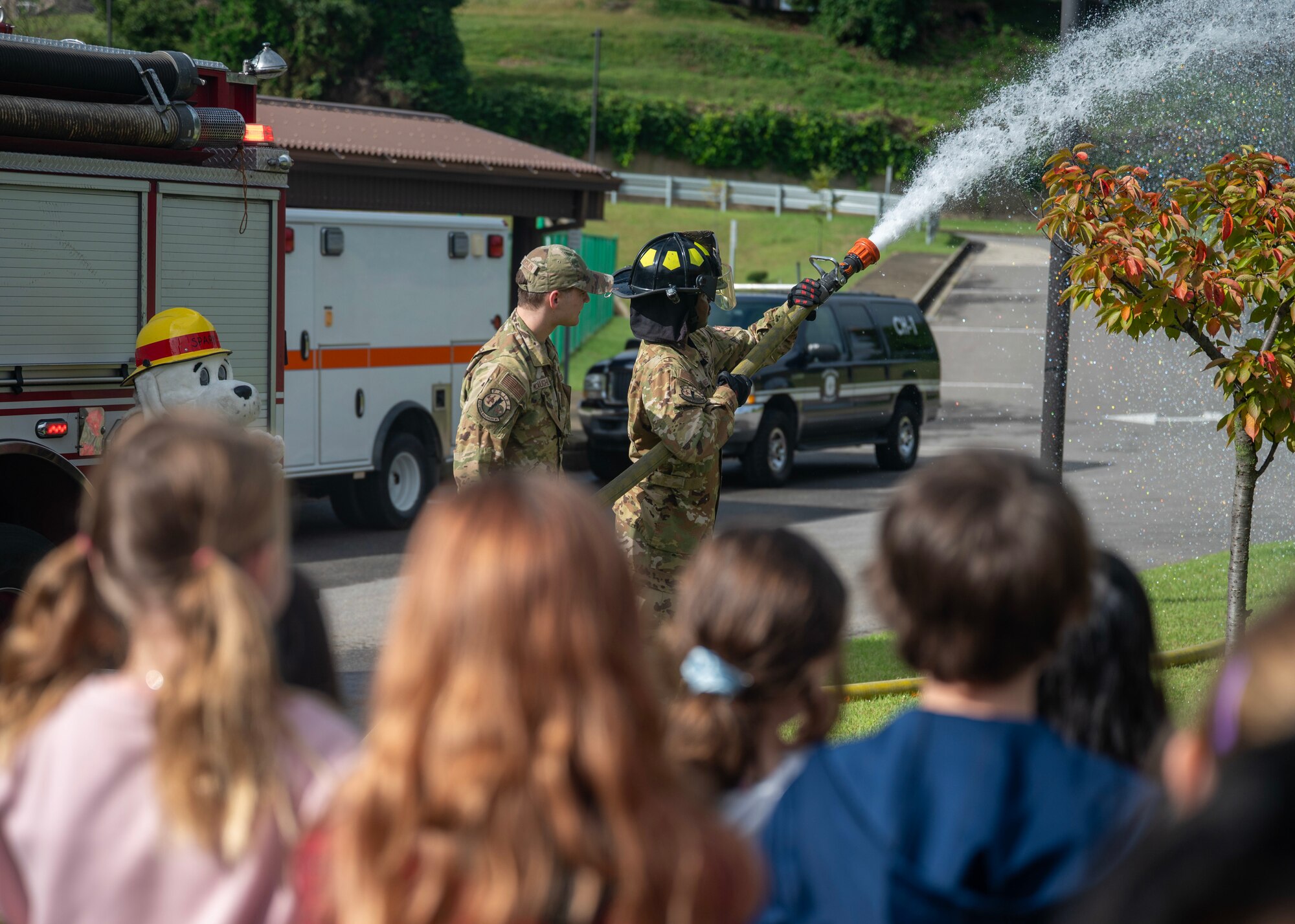 U.S. Air Force Senior Airman Maurice Chambers and Senior Airman Jacon McLaughlin, 51st Civil Engineer Squadron firefighters, spray a hose as a demonstration during Fire Prevention Week at Osan Air Base, Republic of Korea, Oct. 8, 2025. Fire Prevention Week is observed each year during the week of Oct. 9 in commemoration of the Great Chicago Fire of 1871. (U.S. Air Force photos by Staff Sgt. Sarah Williams)