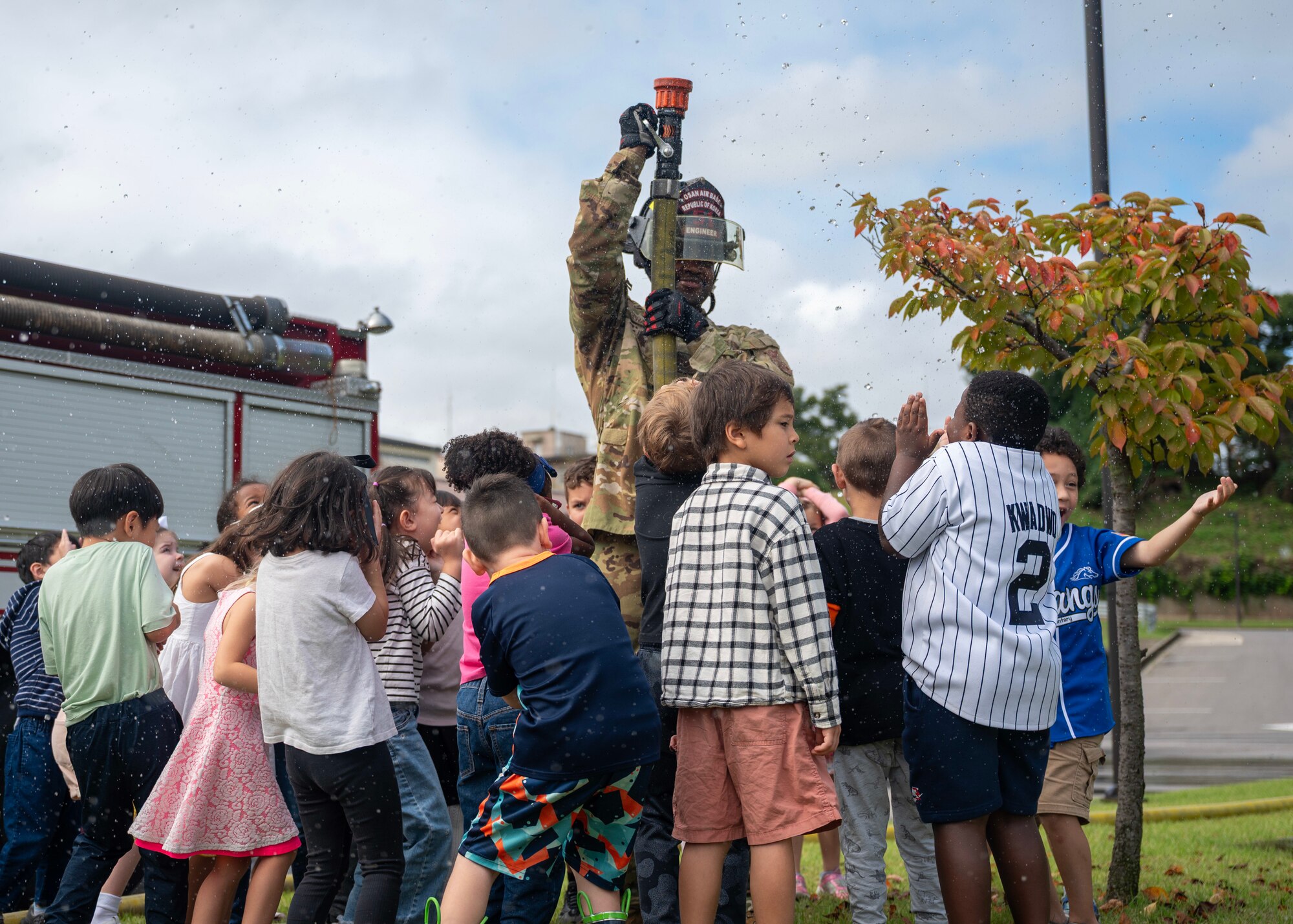 U.S. Air Force Senior Airman Maurice Chambers, 51st Civil Engineer Squadron firefighter, sprays a hose during Fire Prevention Week at Osan Air Base, Republic of Korea, Oct. 8, 2025. Fire Prevention Week focuses on providing the knowledge and tools to react quickly during a fire emergency. (U.S. Air Force photos by Staff Sgt. Sarah Williams)