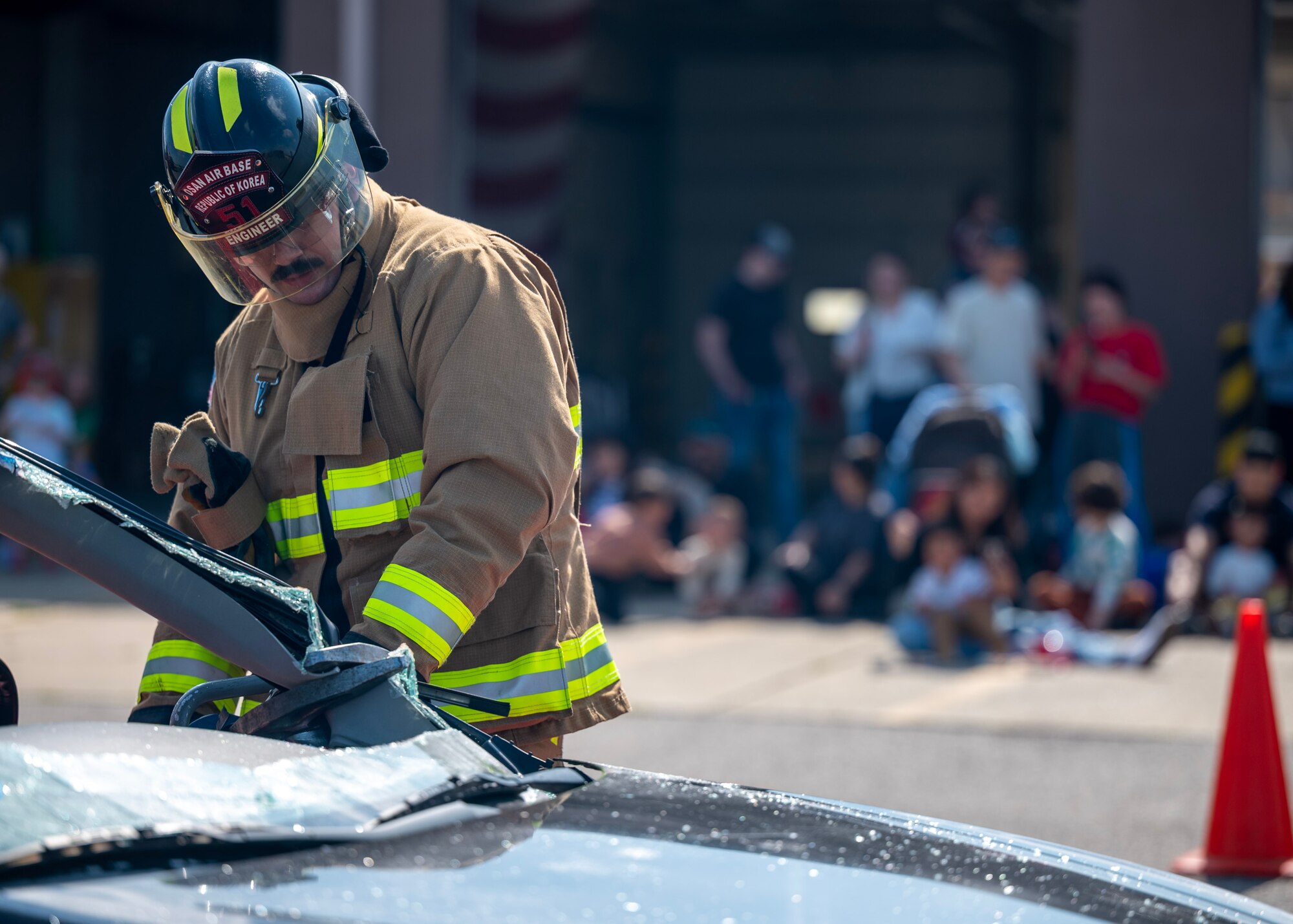 U.S. Air Force Senior Airman Aidan Lohr, 51st Civil Engineer Squadron firefighter, uses a Jaws of Life cutter to remove a car hood at an open house event during Fire Prevention Week at Osan Air Base, Republic of Korea, Oct. 11, 2025. The Jaws of Life can cut through a car’s metal frame allowing firefighters to remove a victim without causing additional harm. (U.S. Air Force photos by Staff Sgt. Sarah Williams)