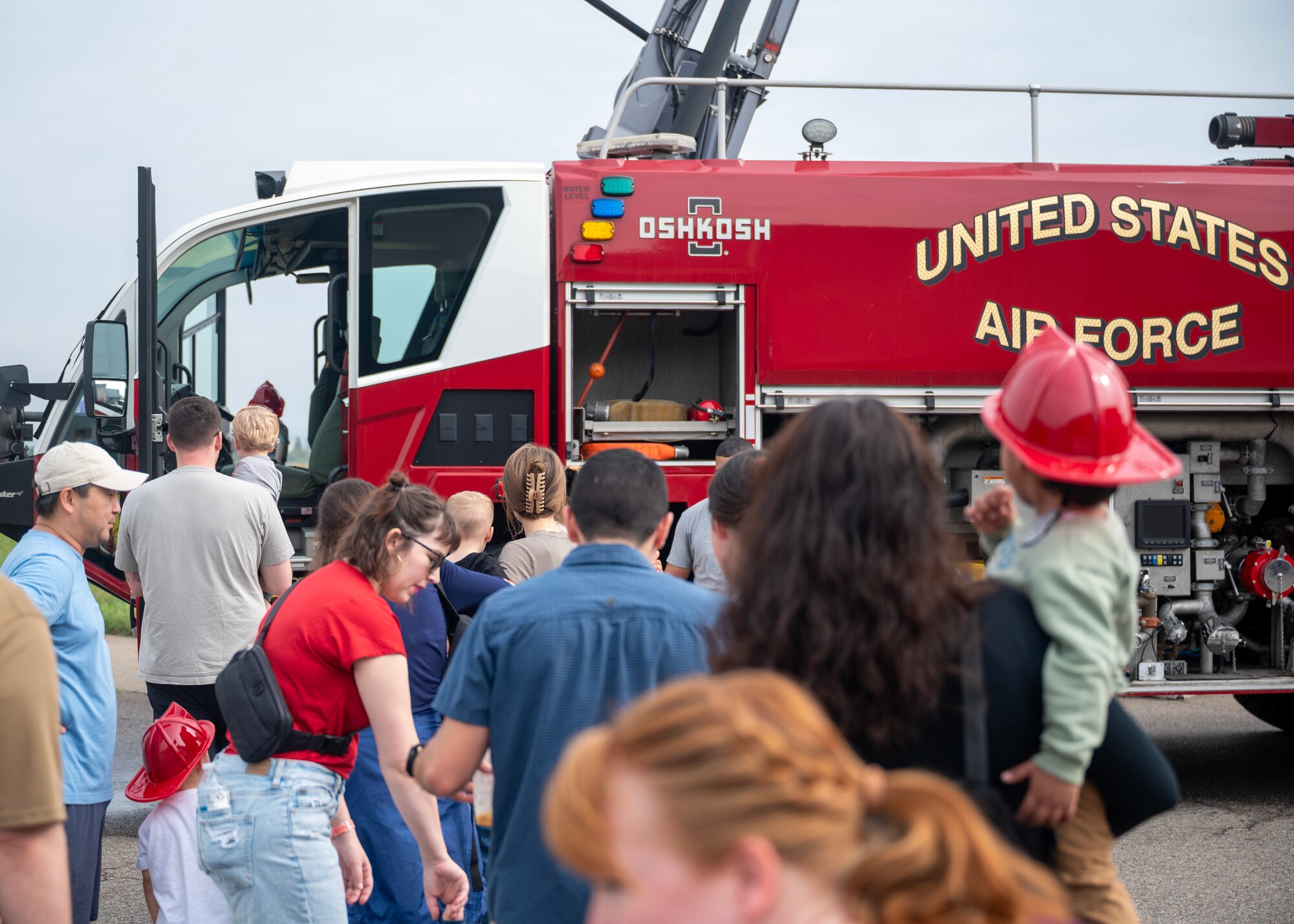 Families line up to tour a fire truck at an open house event during Fire Prevention Week at Osan Air Base, Republic of Korea, Oct. 11, 2025. This year’s Fire Prevention Week theme was “Charge into Fire Safety: Lithium-ion Batteries in Your Home”, serving as a reminder that fires can start from something as small as a battery. (U.S. Air Force photos by Staff Sgt. Sarah Williams)