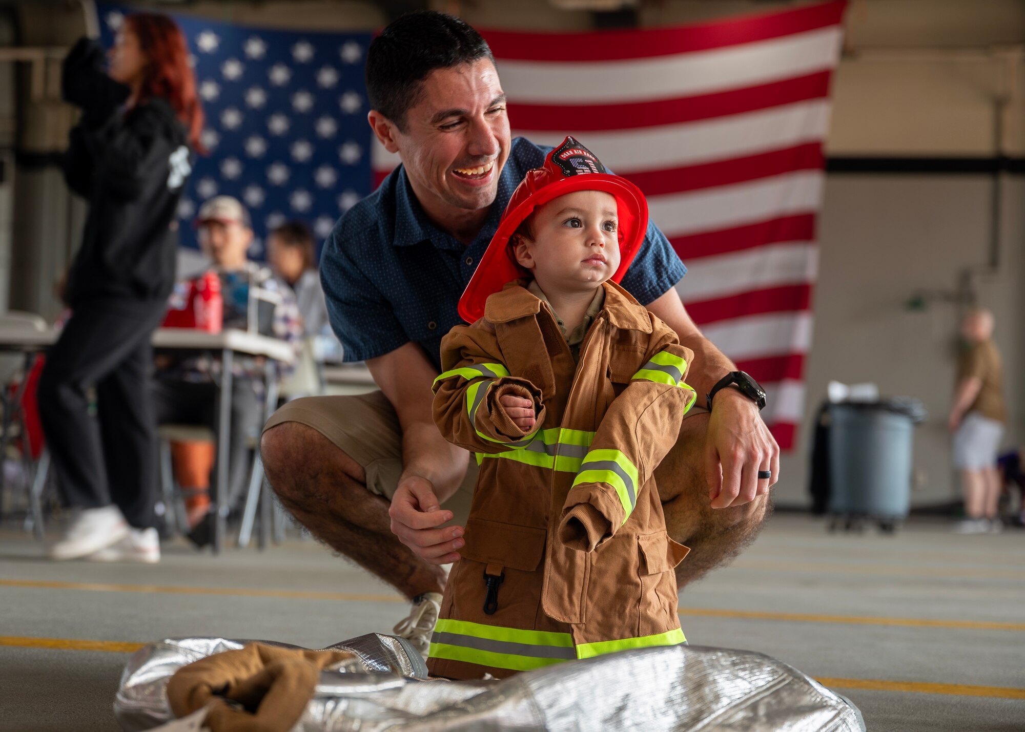 Andrew Quallio, 607 Air Operations Center air mobility division chief, and his son Kai Quallio pose for a photo during Fire Prevention Week at Osan Air Base, Republic of Korea, Oct. 11, 2025. Fire Prevention Week focuses on providing the knowledge and tools to react quickly during a fire emergency. (U.S. Air Force photos by Staff Sgt. Sarah Williams)