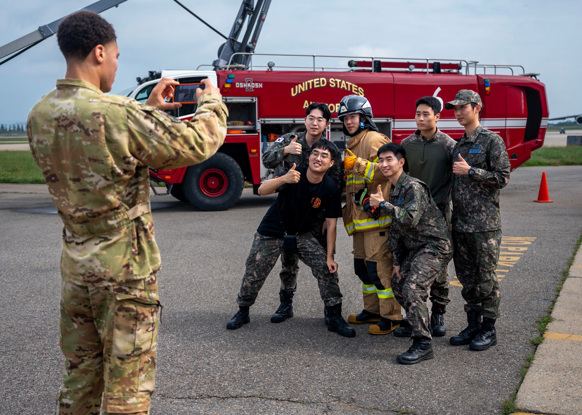 U.S. Air Force Staff Sgt. Domitrius Johnson, 51st Civil Engineer Squadron firefighter, takes a photo of Republic of Korea firefighters at an open house event during Fire Prevention Week at Osan Air Base, Republic of Korea, Oct. 11, 2025. Fire Prevention Week is observed each year during the week of Oct. 9 in commemoration of the Great Chicago Fire of 1871. (U.S. Air Force photos by Staff Sgt. Sarah Williams)