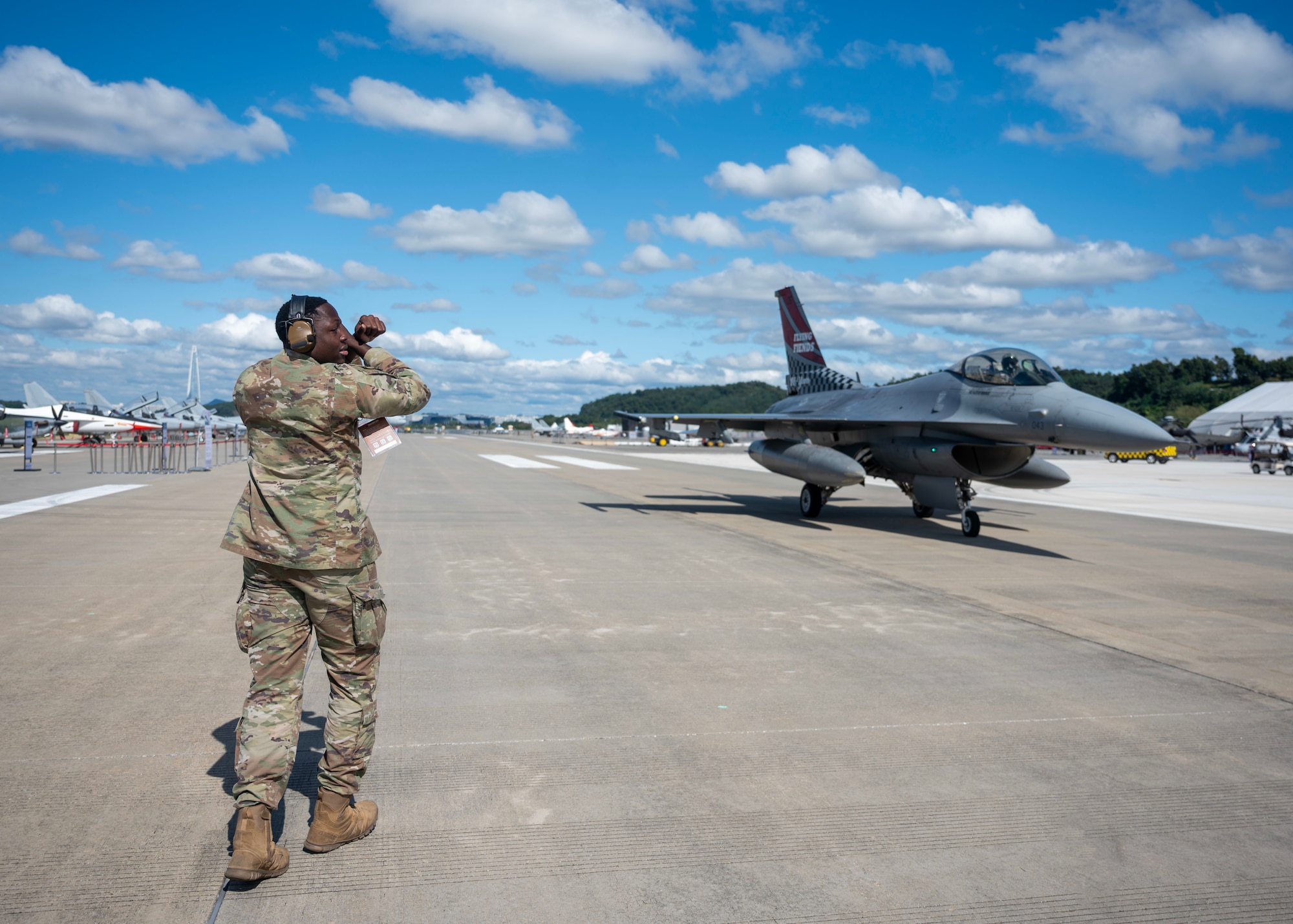 U.S. Air Force Staff Sgt. David Jean, 36th Fighter Generation Squadron dedicated crew chief, marshals an F-16 Fighting Falcon at Seoul Air Base, Republic of Korea, Oct. 16, 2025. The 2025 Seoul International Aerospace and Defense Exhibition strengthened the U.S.-ROK alliance and regional security through cooperation, dialogue, and shared innovation. (U.S. Air Force photo by Staff Sgt. Sarah Williams)