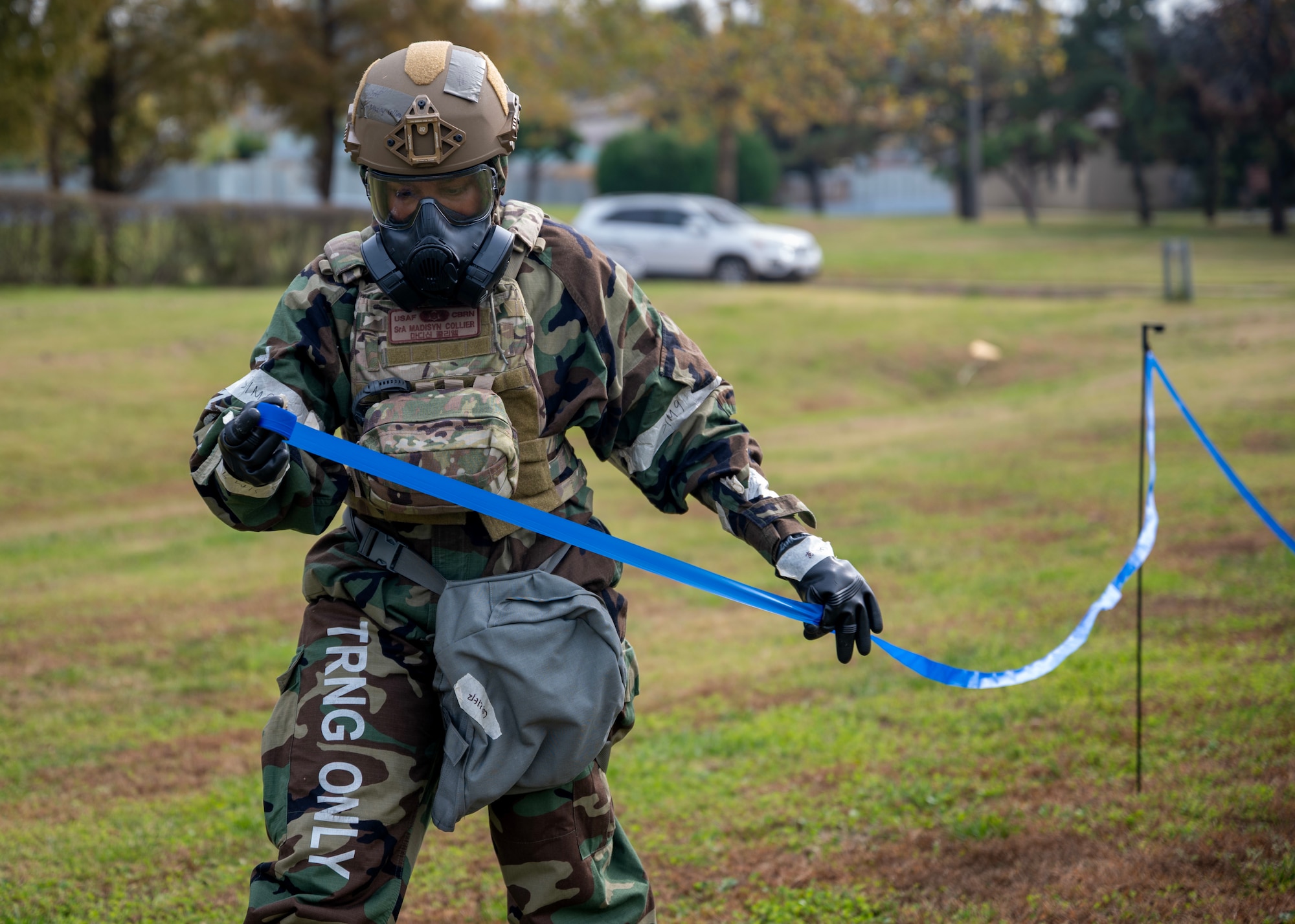 U.S. Air Force Senior Airman Madisyn Collier, 51st Civil Engineer Squadron emergency management technician, stands up a cordon during a chemical, biological, radiological and nuclear exercise at Osan Air Base, Republic of Korea, Oct. 30, 2025. Members practiced site surveys, sampling and unexploded ordnance protocols to enhance readiness for future contingencies.  (U.S. Air Force photo by Staff Sgt. Sarah Williams)