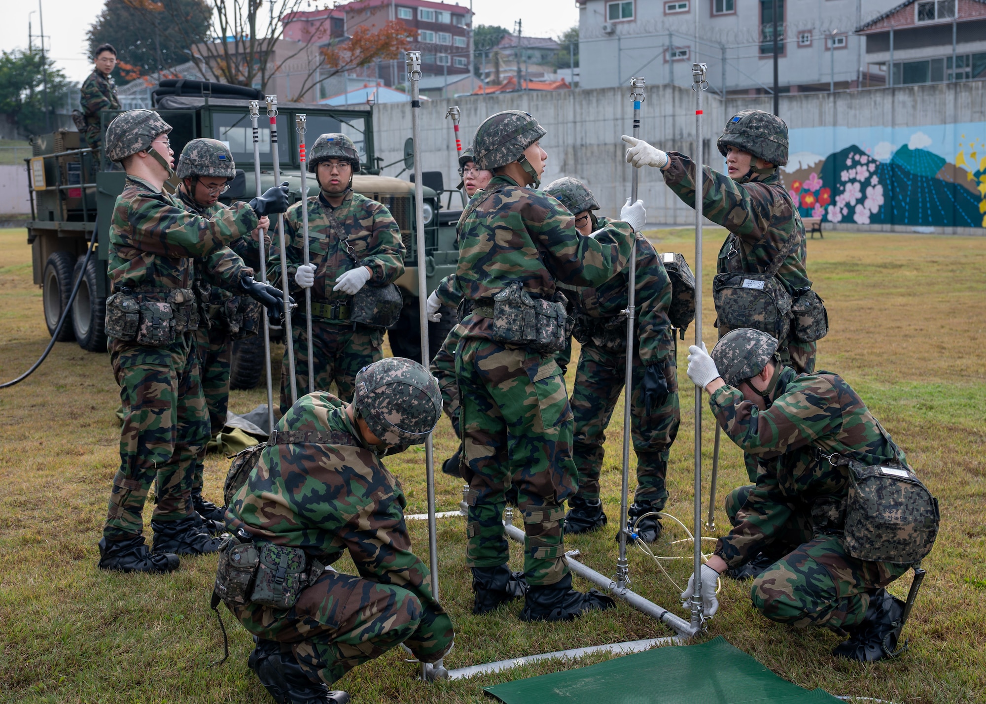 Republic of Korea Air Force members set up a decontamination shower during a chemical, biological, radiological, and nuclear exercise at Osan Air Base, ROK, Oct. 30, 2025. Through realistic scenarios, participants identified operational gaps and developed new solutions to strengthen CBRN readiness. (U.S. Air Force photo by Staff Sgt. Sarah Williams)