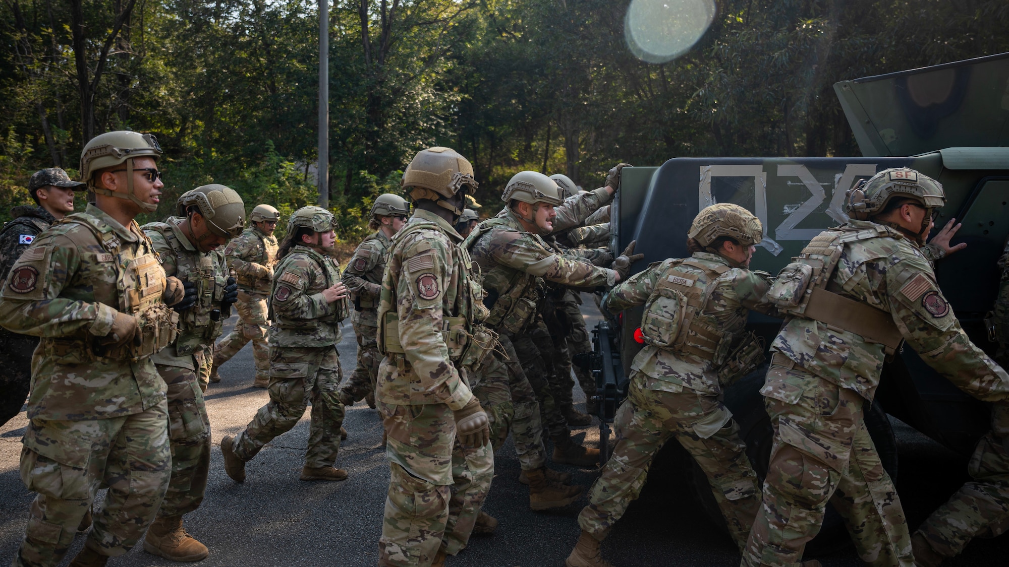 Members of the 51st Security Forces Squadron push a humvee at Osan Air Base, Republic of Korea, Oct. 29, 2025. Combat Readiness Course fostered teamwork, situational awareness, and proficiency in core tasks vital to base defence. (U.S. Air Force photo by Staff Sgt. Sarah Williams)